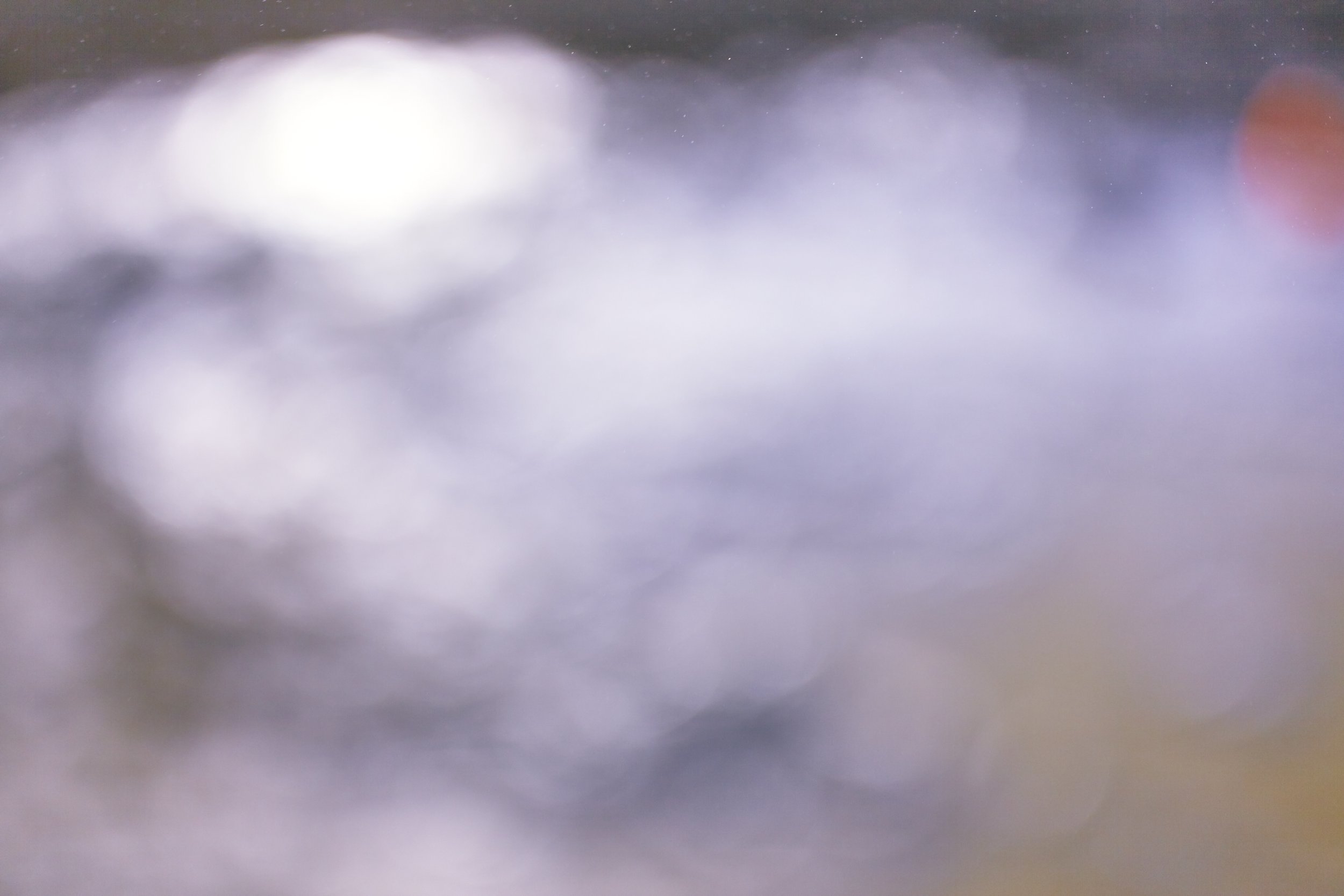Abstract, blurred image with soft lighting and subtle color tones, indistinct shapes, and no clear subject.
