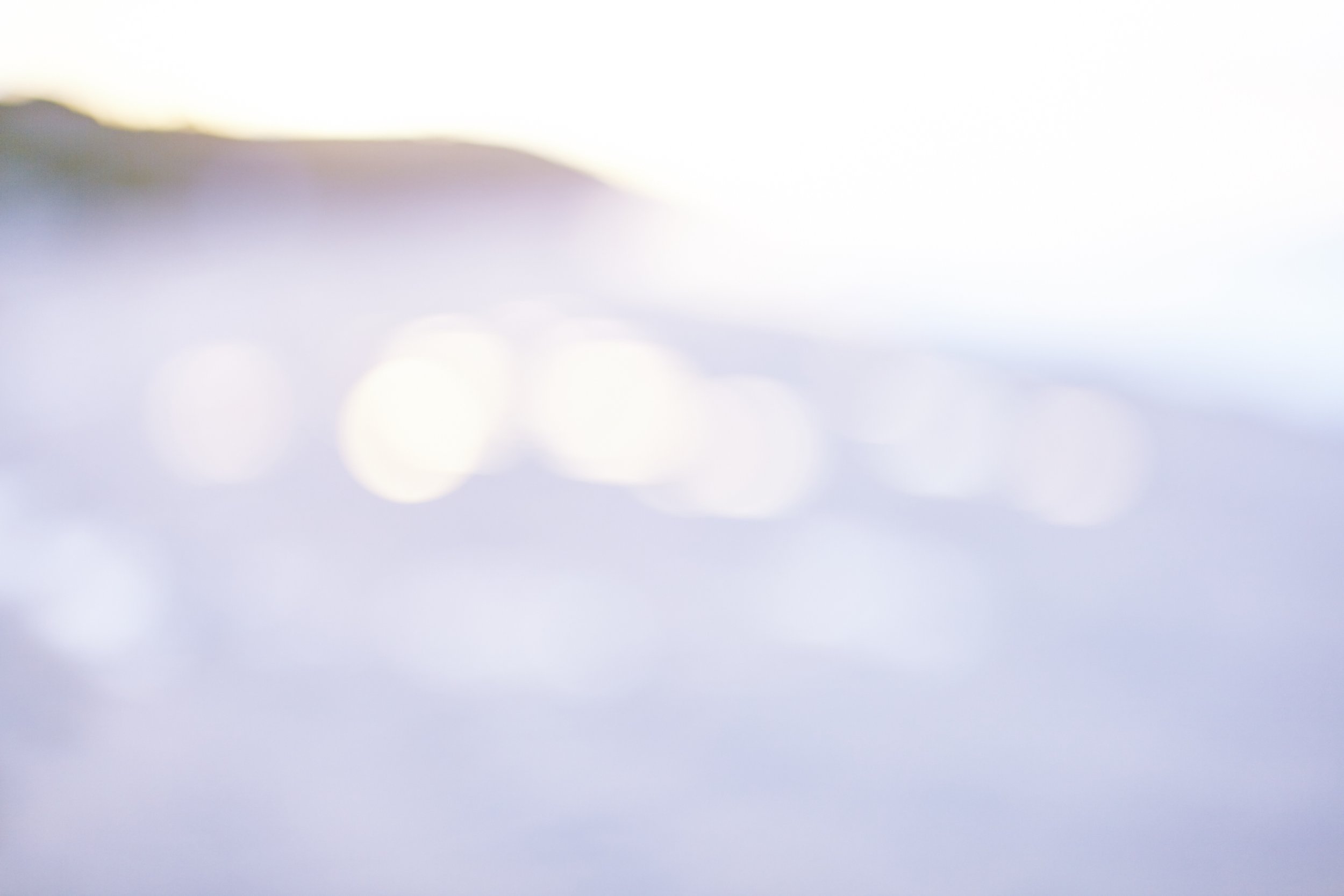 Abstract, blurred image with soft pastel colors and circular light bokeh effects.