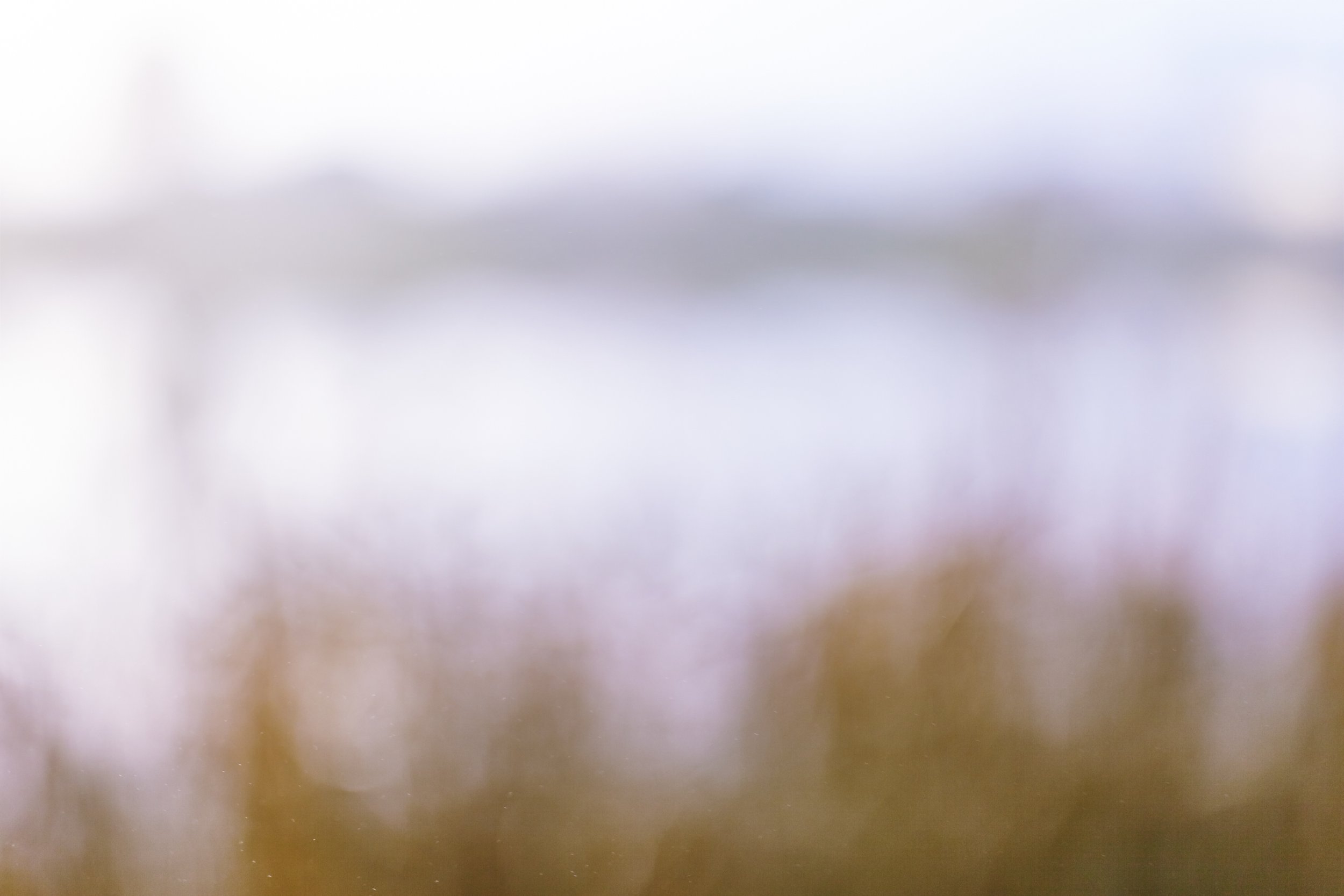 Blurred image with soft colors blending into each other, difficult to identify objects clearly.