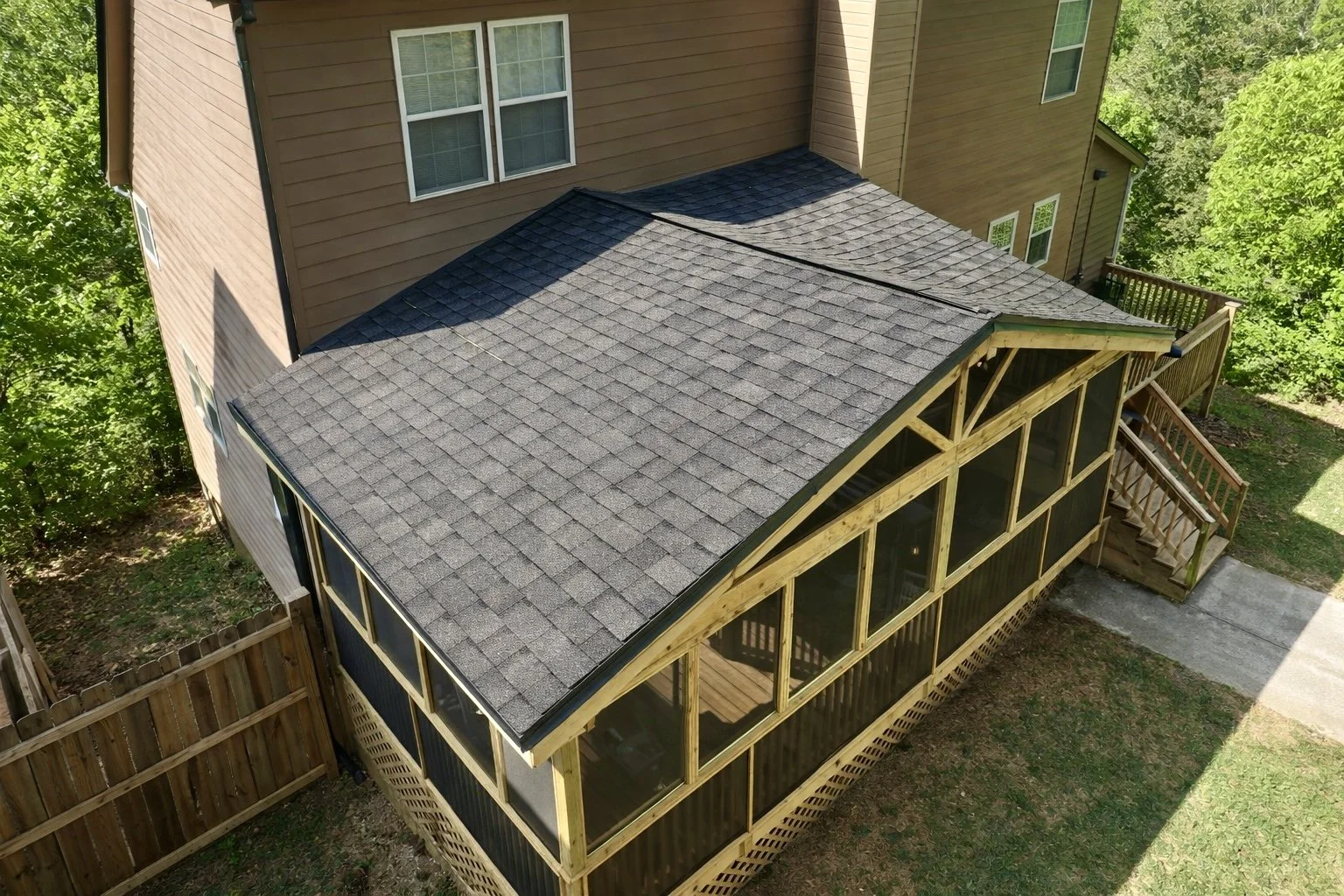 Custom screened-in porch addition featuring a full shingle roof, wood framing, and screened walls for a comfortable outdoor living space.