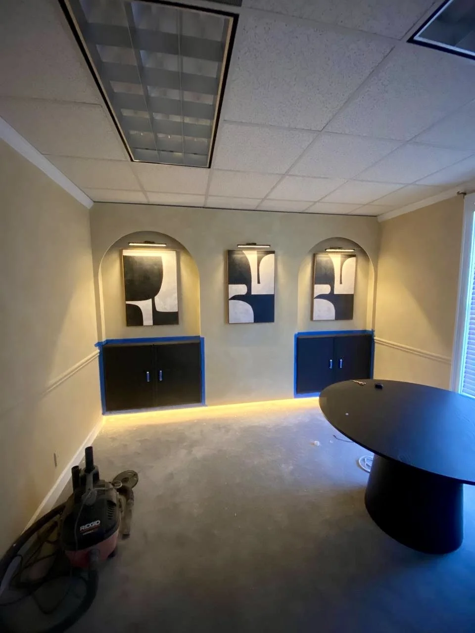 Custom wall niches, cabinetry, artwork lighting, and accent lighting create a distinctive built-in feature for this office.
