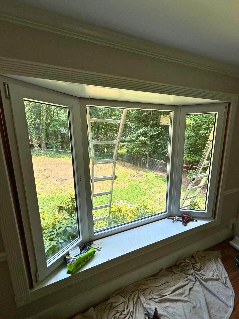 New bay window installation featuring a large center pane and operable side windows for added natural light and ventilation.