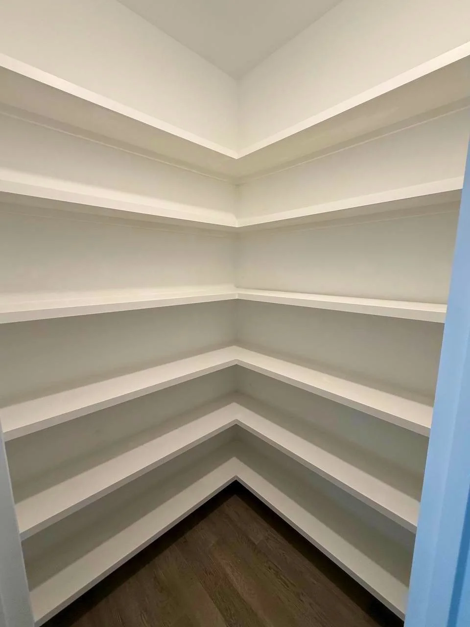 Floor-to-ceiling wraparound shelving provides ample, organized storage while making efficient use of the entire pantry.