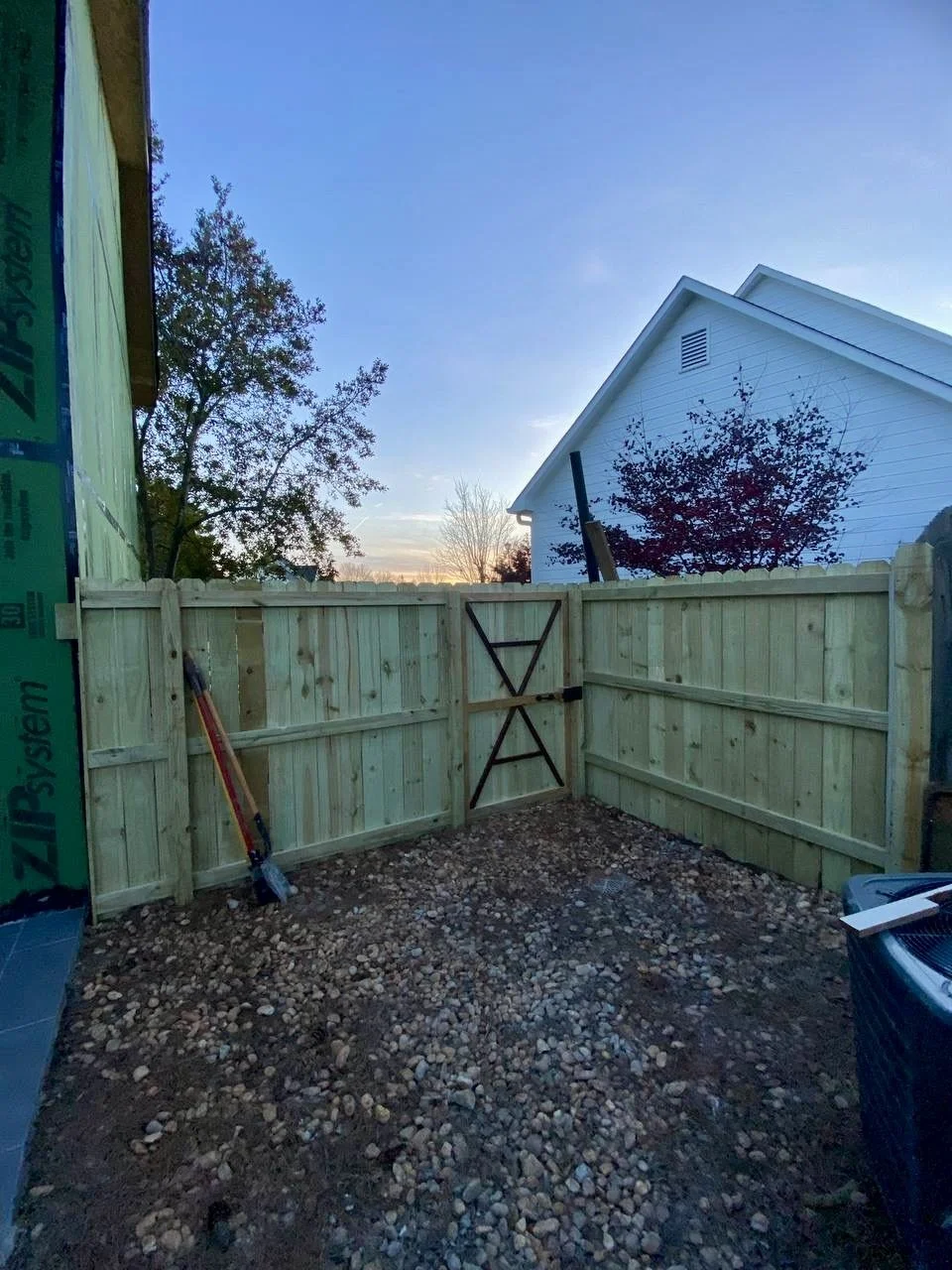 New pressure-treated wood privacy fencing and a custom gate installed to create a secure, enclosed outdoor space.