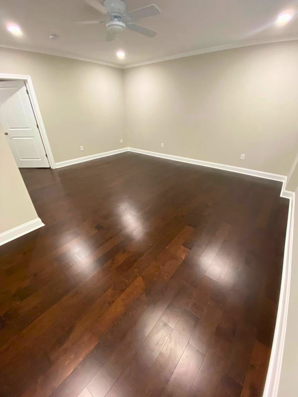 Newly installed dark hardwood flooring gives this bedroom a clean, durable, and sophisticated finish.