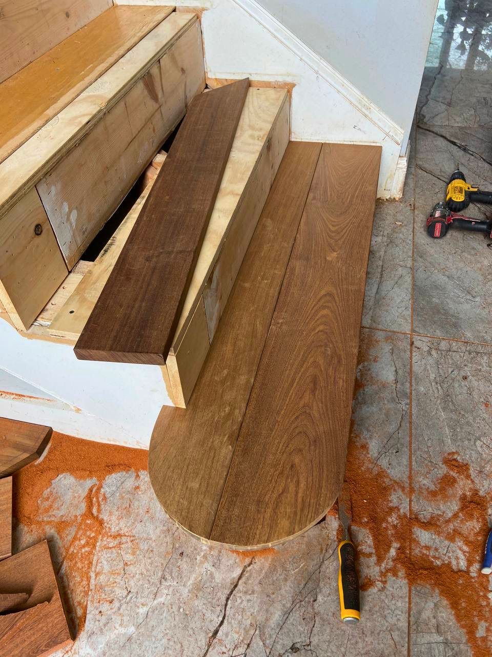 Hardwood stair treads custom-cut and fitted to accommodate the staircase's distinctive rounded bottom step.
