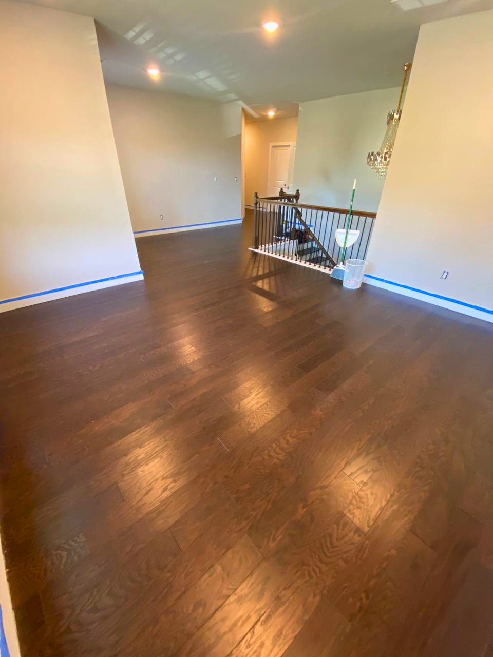 Dark hardwood flooring installed across a spacious upper-level living area for a warm, cohesive finish.