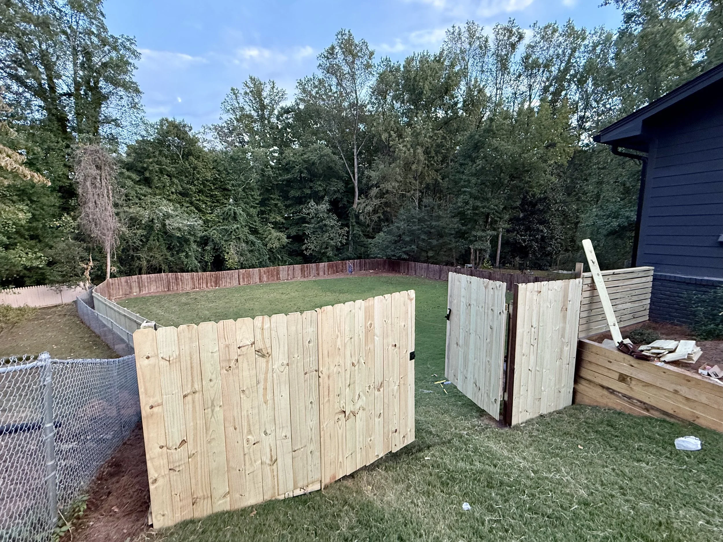 New privacy fence and wide double-gate system provide secure backyard access while blending naturally with the property.