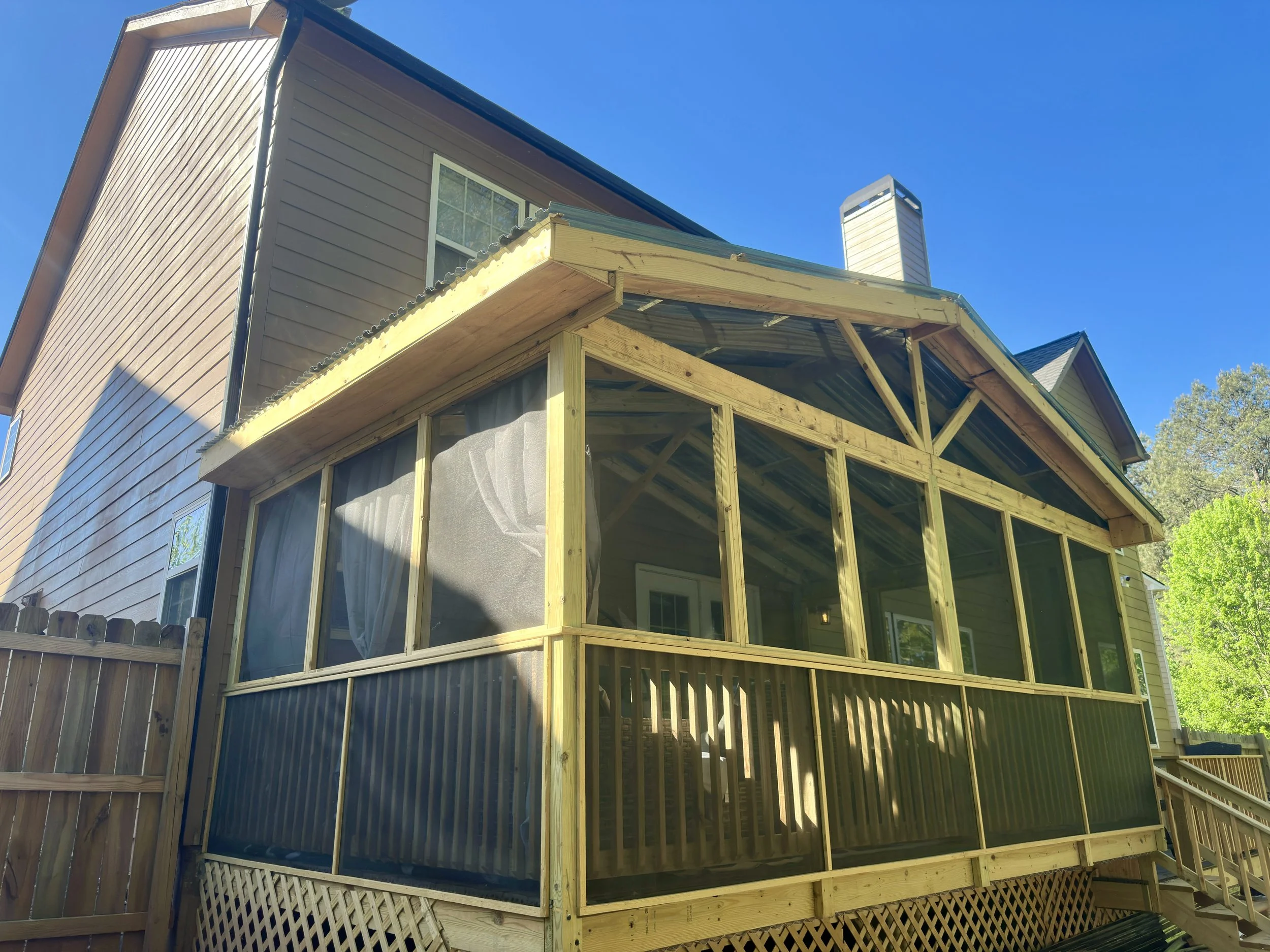 Screened porch built with pressure-treated framing, protective screening, and a covered roof for year-round outdoor enjoyment.