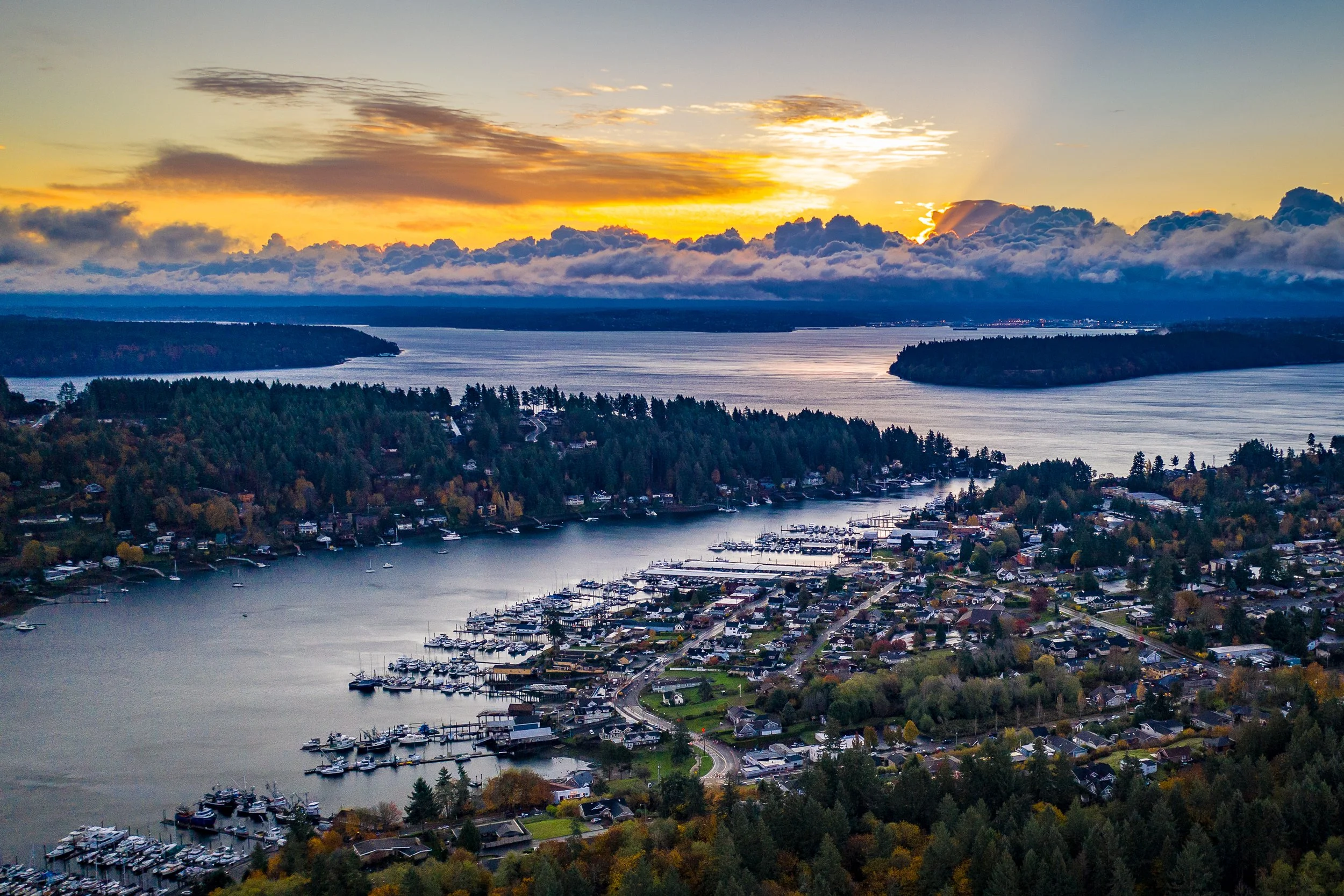 Aerial view of Gig Harbor, WA with a sunset with clouds in the background. Gig Harbor is convenient to Tacoma, Bremerton, Olympia and South King county.