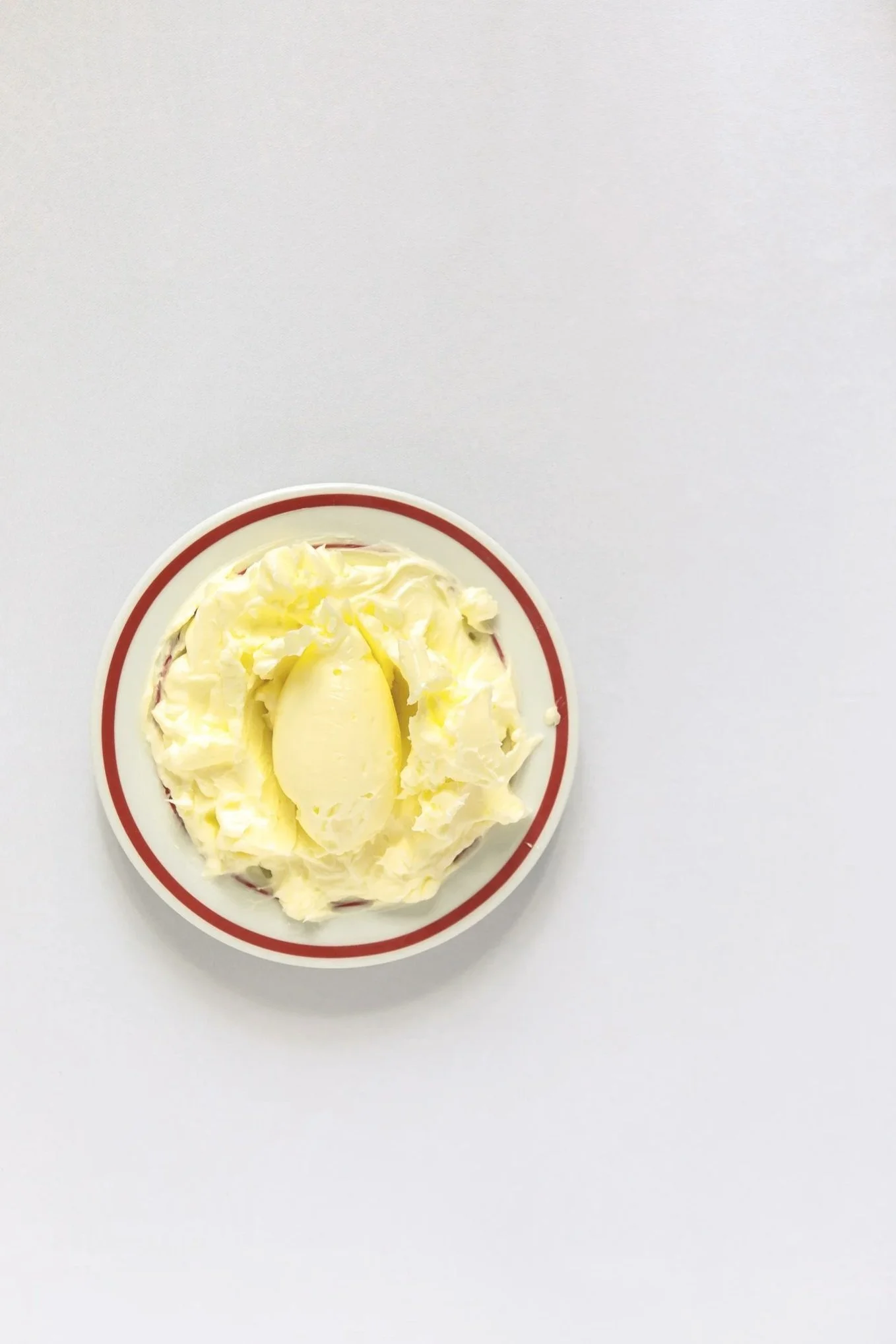 Plate of butter with rocher, on a white surface.