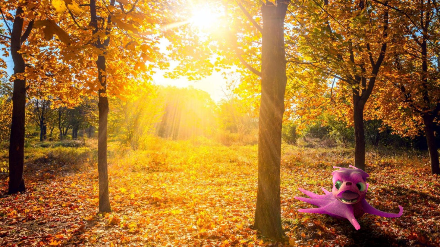 A model of cartoon purple pug-octopus creature with big green eyes and a wide mouth, sitting on autumn leaves in a sunlit forest with orange and yellow foliage.