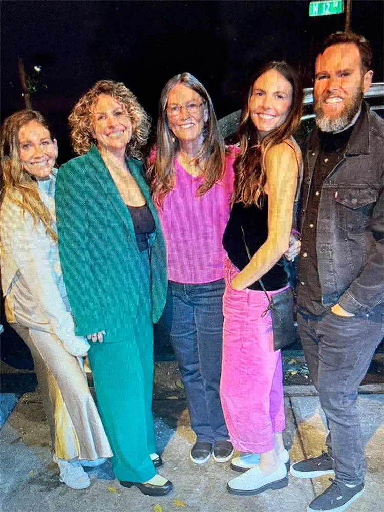 Kaye's family of Five standing together outdoors at night smiling for the camera
