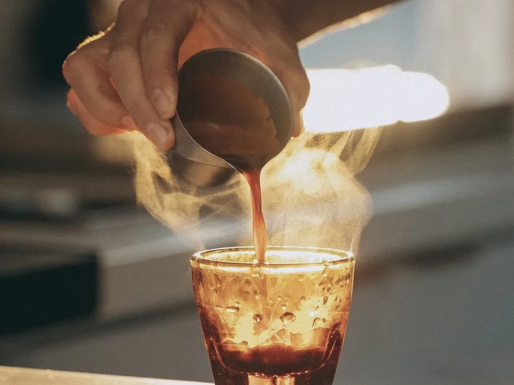 Espresso shot pouring from an Italian espresso machine