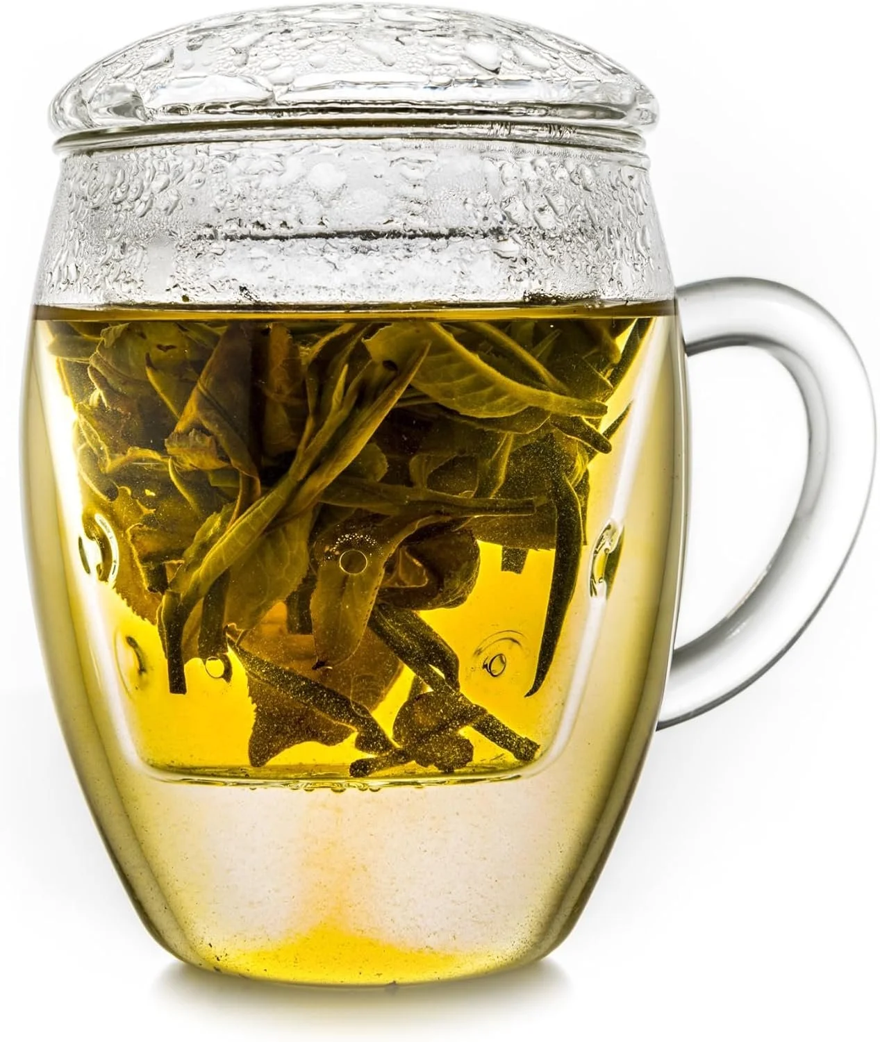 Caneca de vidro transparente com chá e infusor de vidro com folhas em infusão.