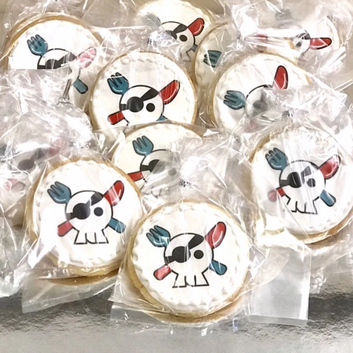 Cookies decorated with pirate-themed skull and crossbones design wrapped in clear plastic.