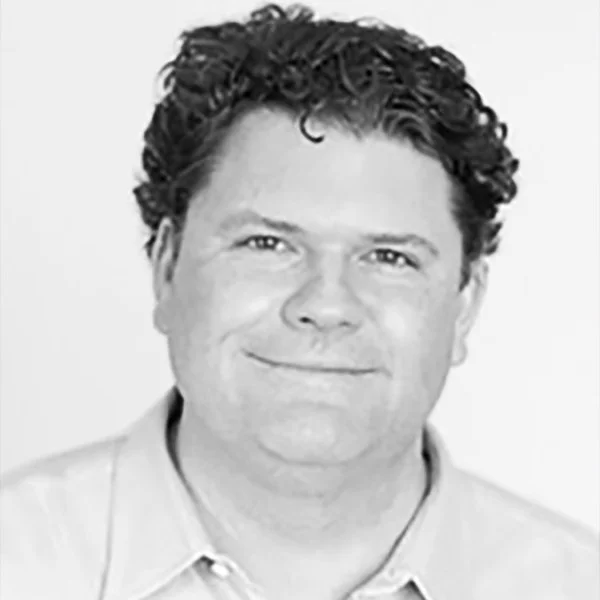 A headshot of a man smiling.
