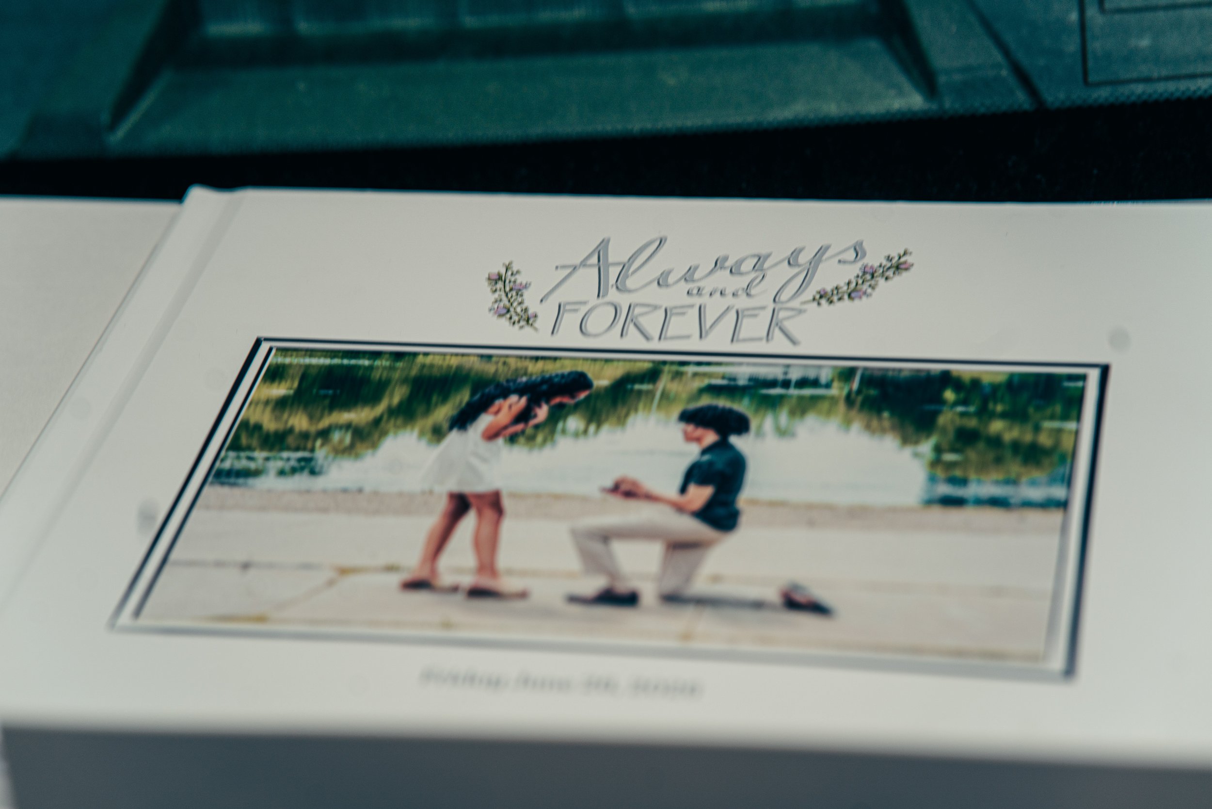 A 20-page photobook with the words "Always and Forever" decorated with floral designs. The cover features the moment the young man asks his future wife to marry him capture perfectly.