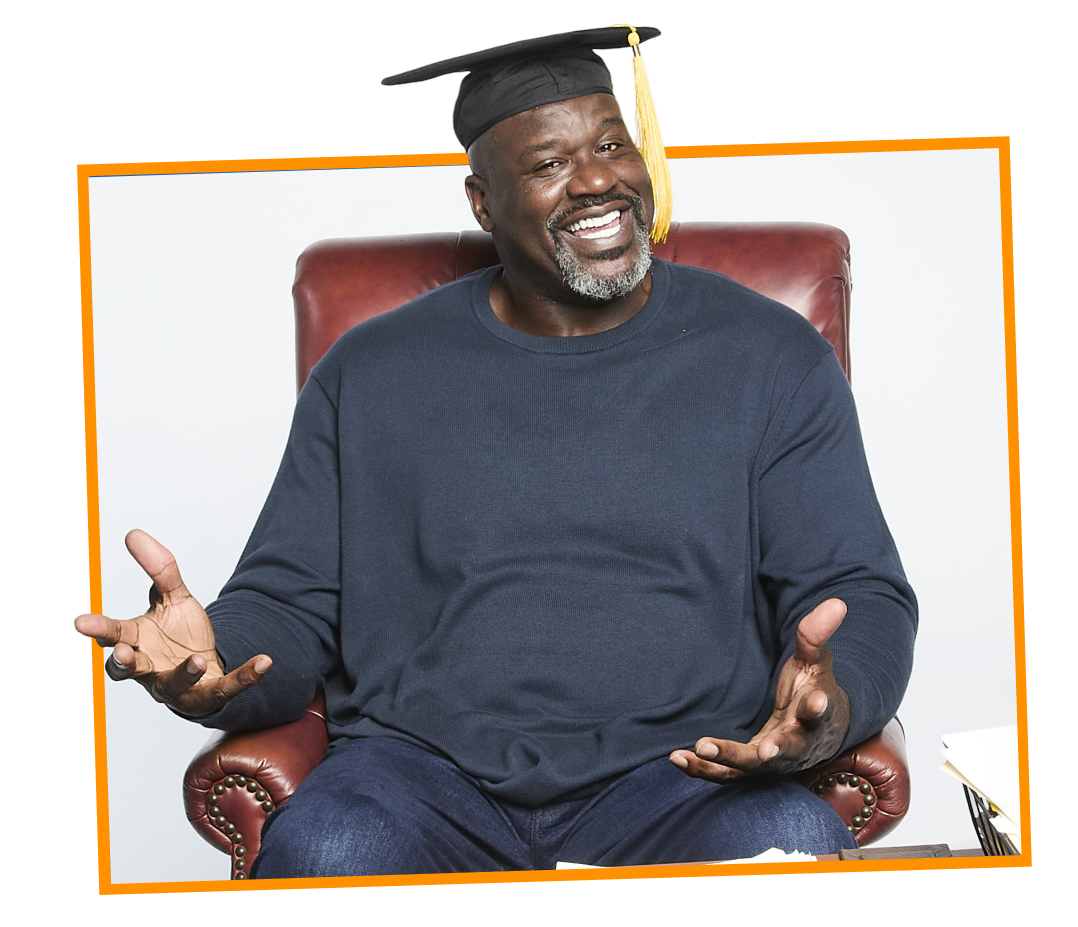 A joyful man wearing a graduation cap, sitting in a red chair, gesturing with hands, smiling widely.