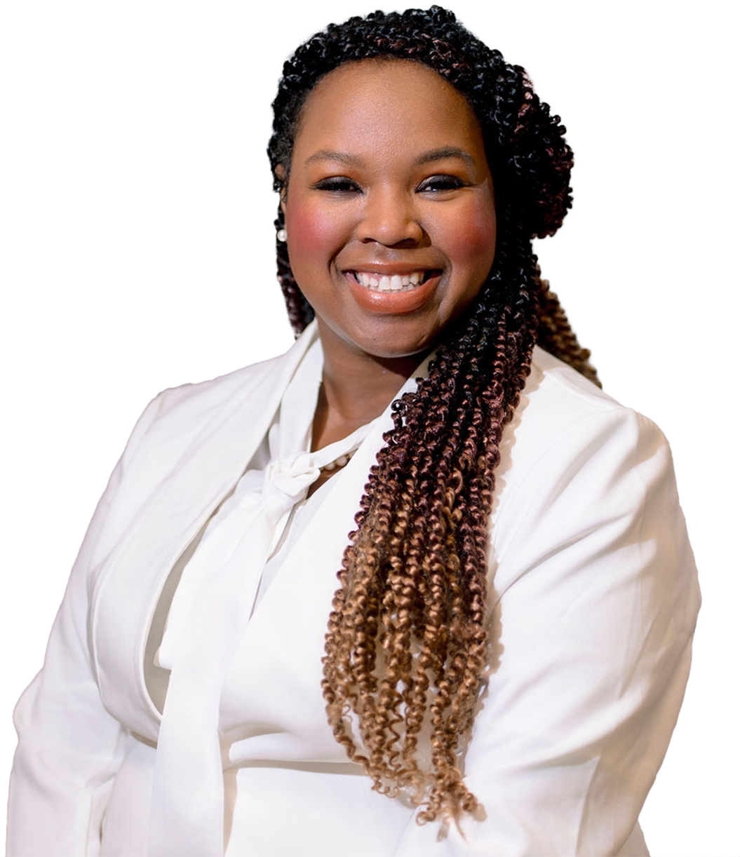 A woman with long braided hair smiling at the camera, wearing a white blazer.