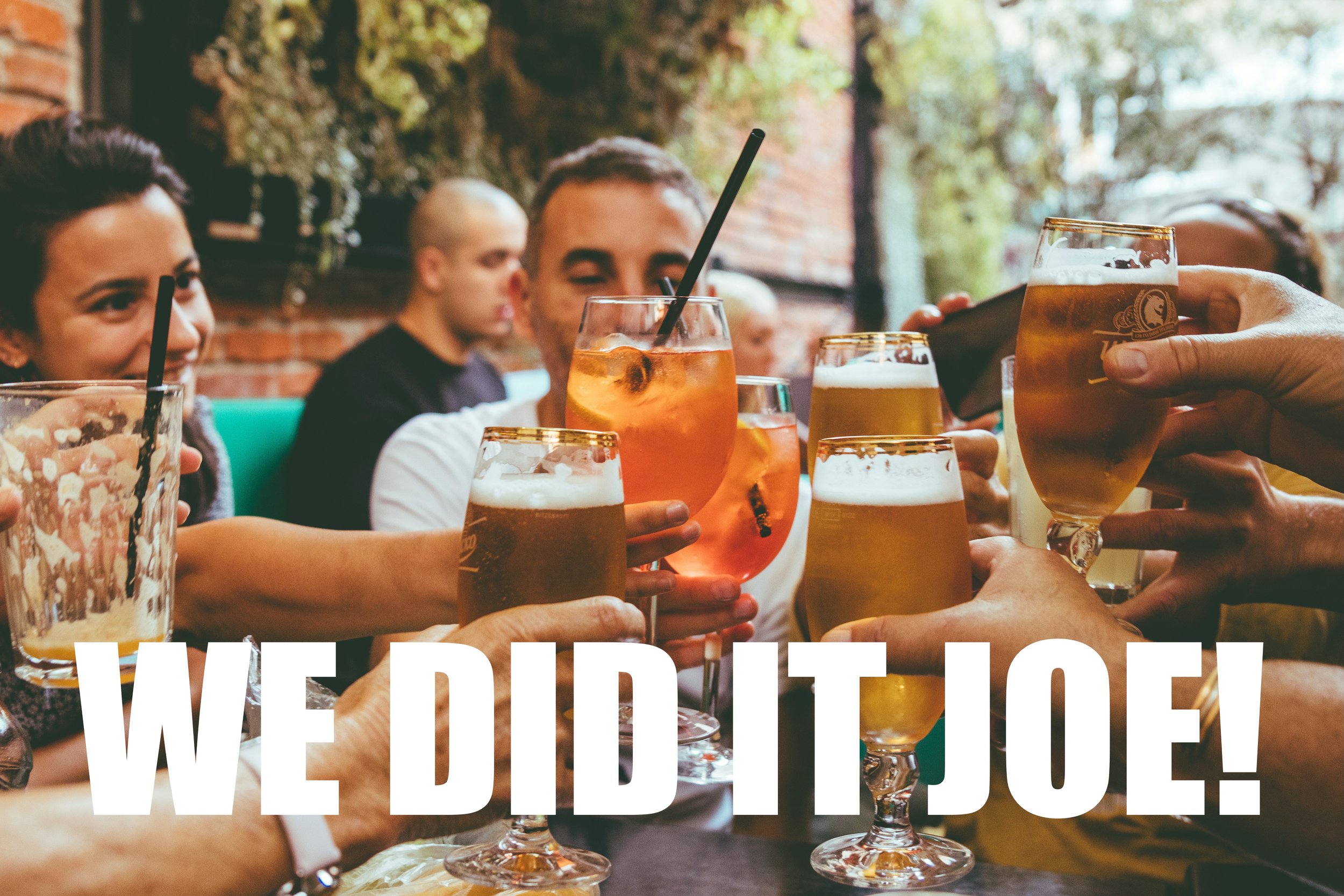 People clinking glasses in a pub. Text reads "We did it, Joe!".