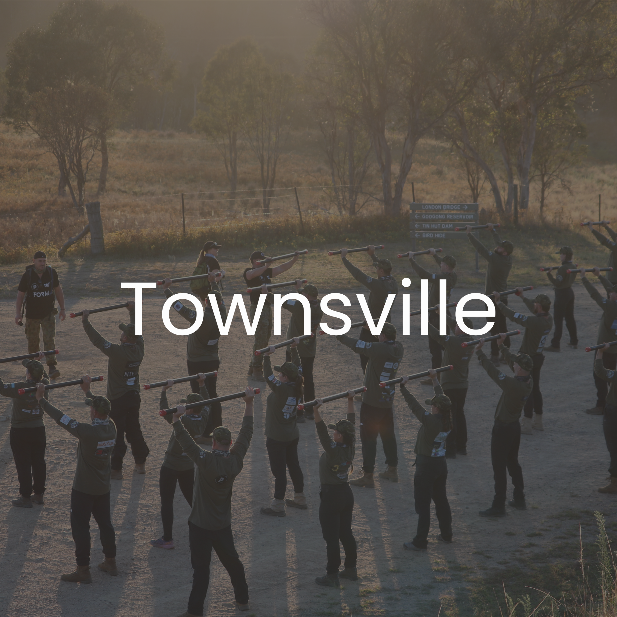 30 Unbroken participants participating in an outdoor training exercise, with trees in the background during sunset.
