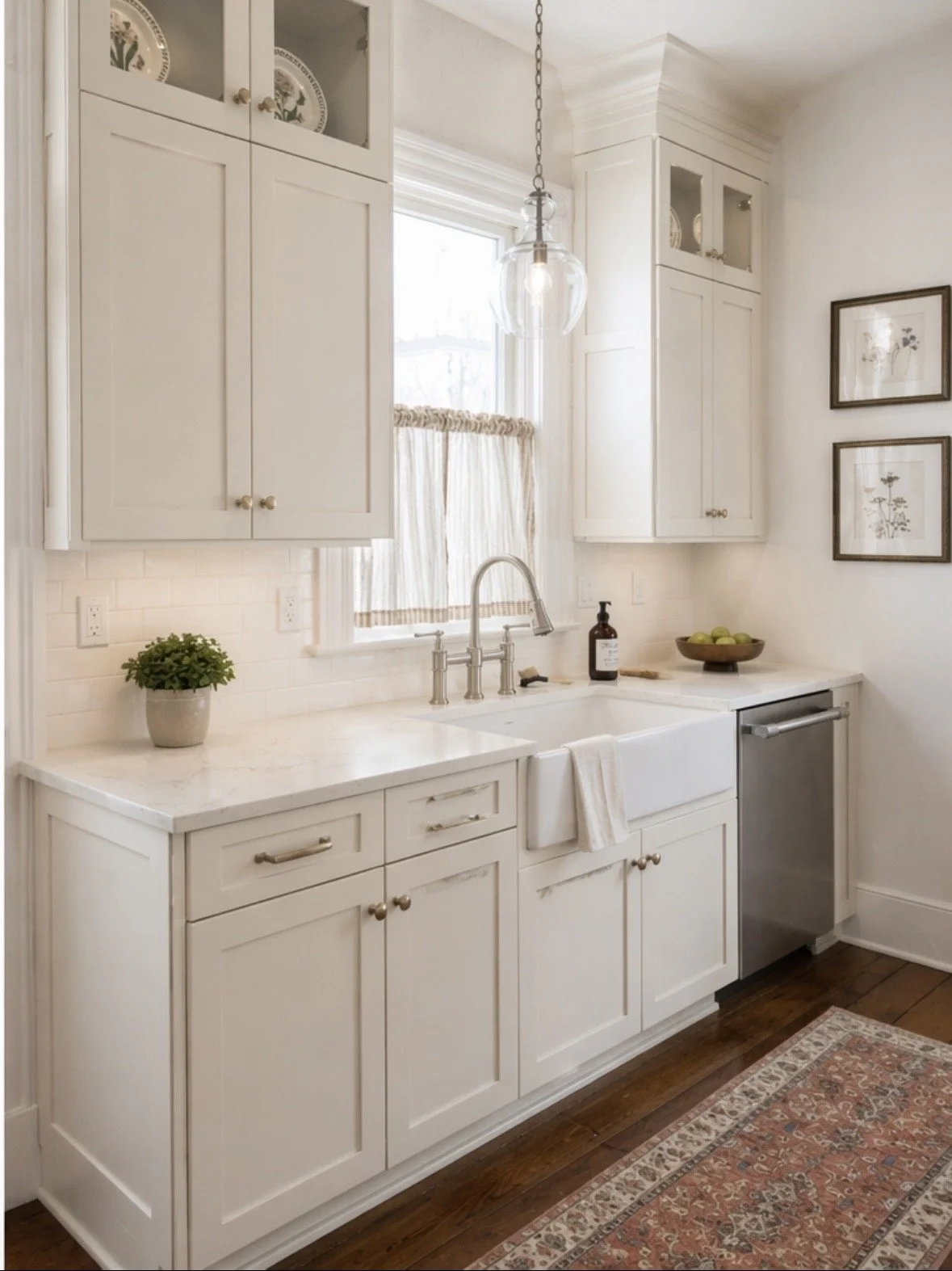 white kitchen cabinets with sink at center and decorative rug on the floor