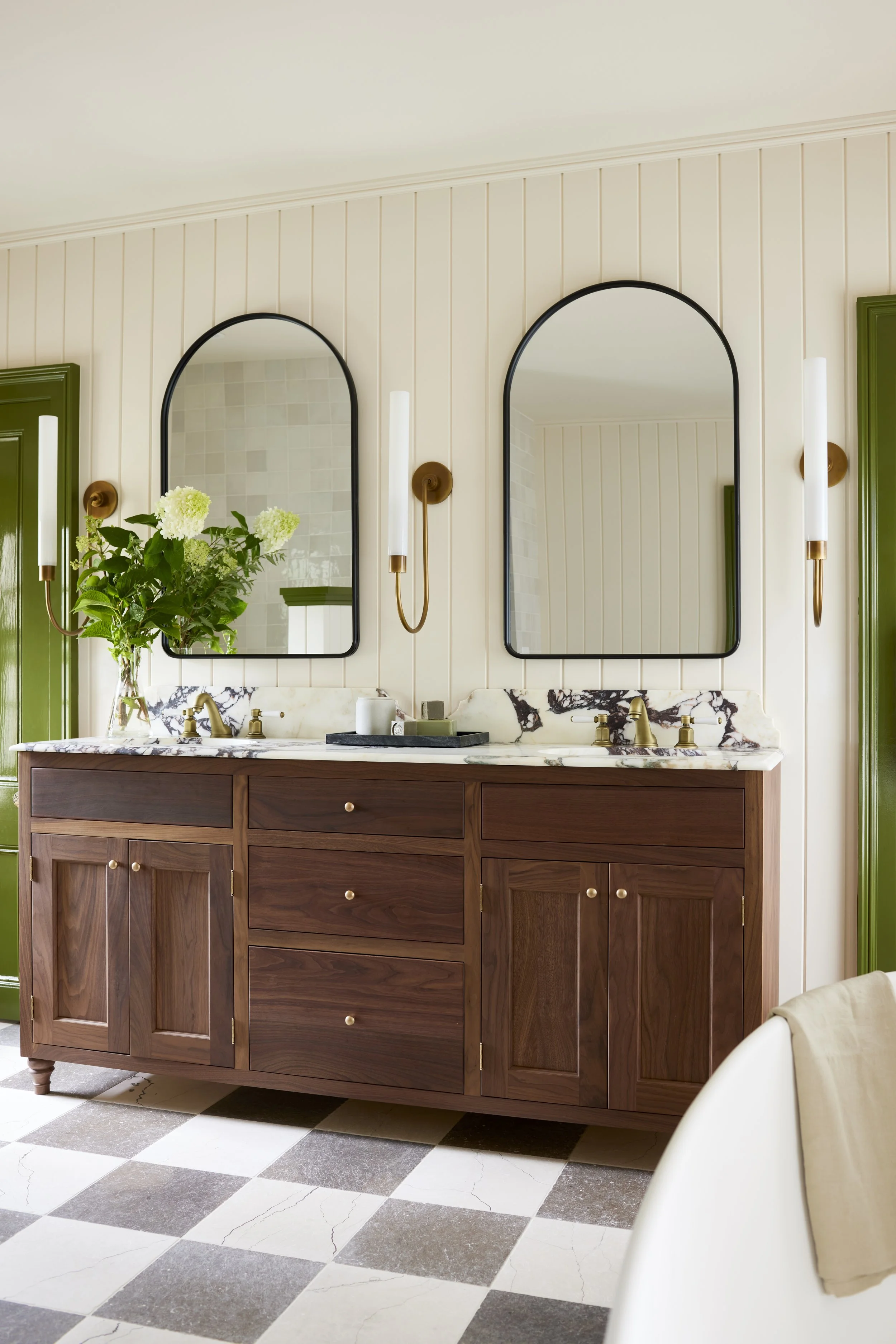 wood double vanity with marble countertop and two black mirrors surrounded by decorative light fixtures