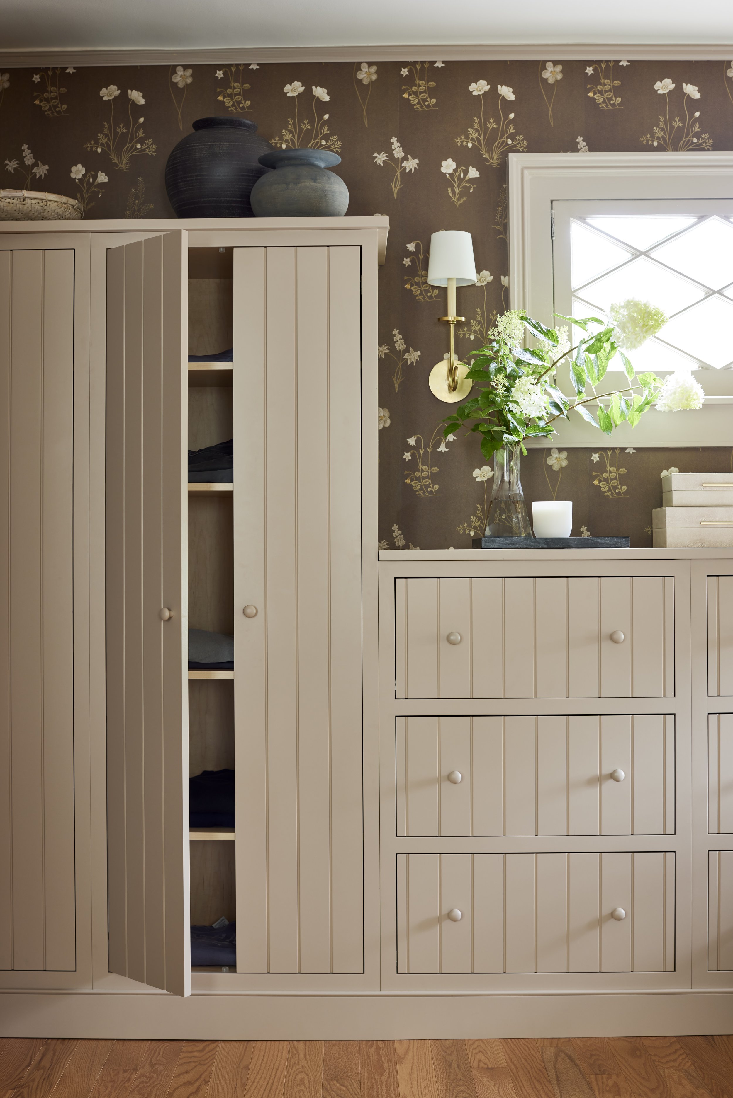 dressing room cabinetry with decorative wallpaper in the background