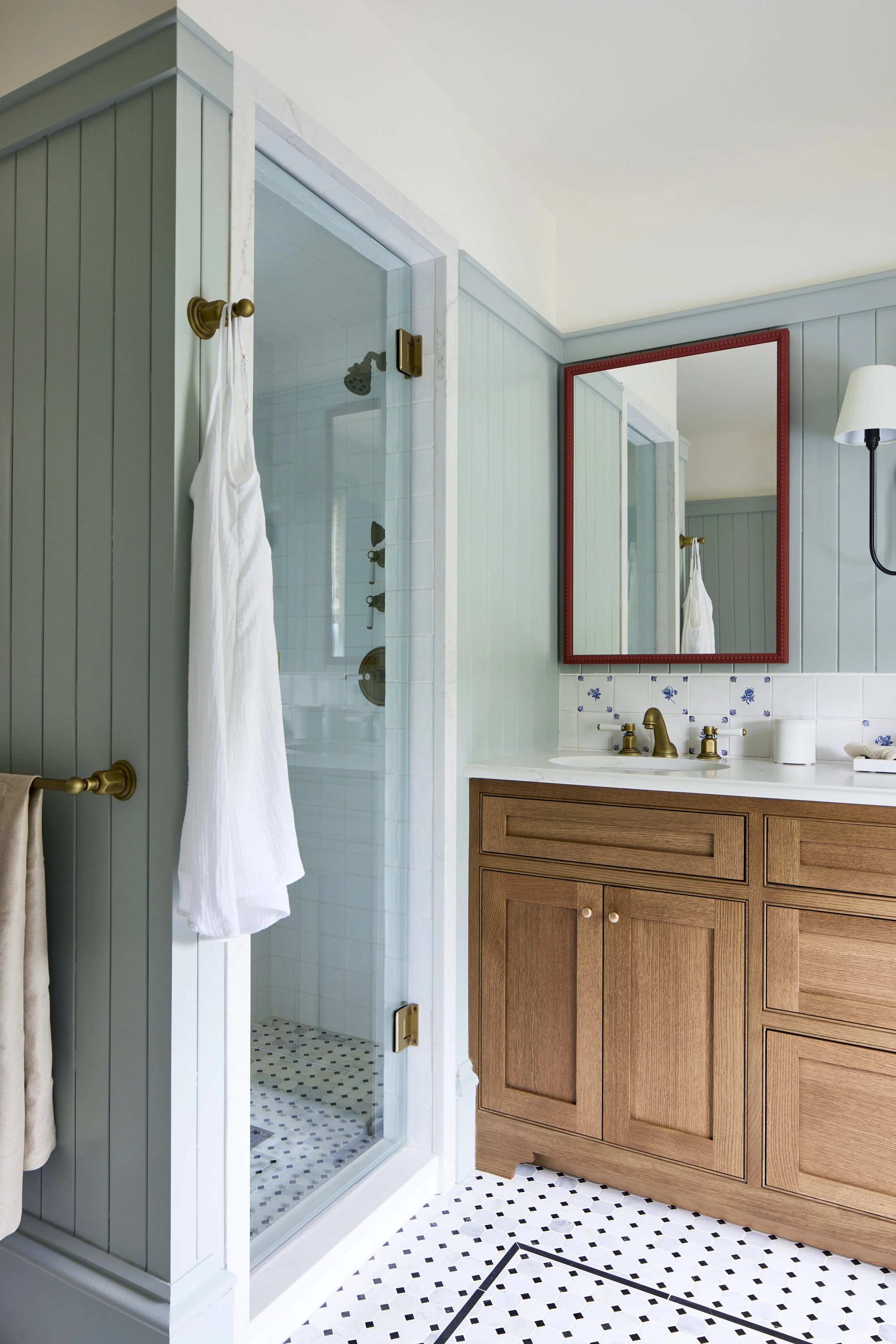 bathroom with blue walls, wood cabinetry, and red mirror