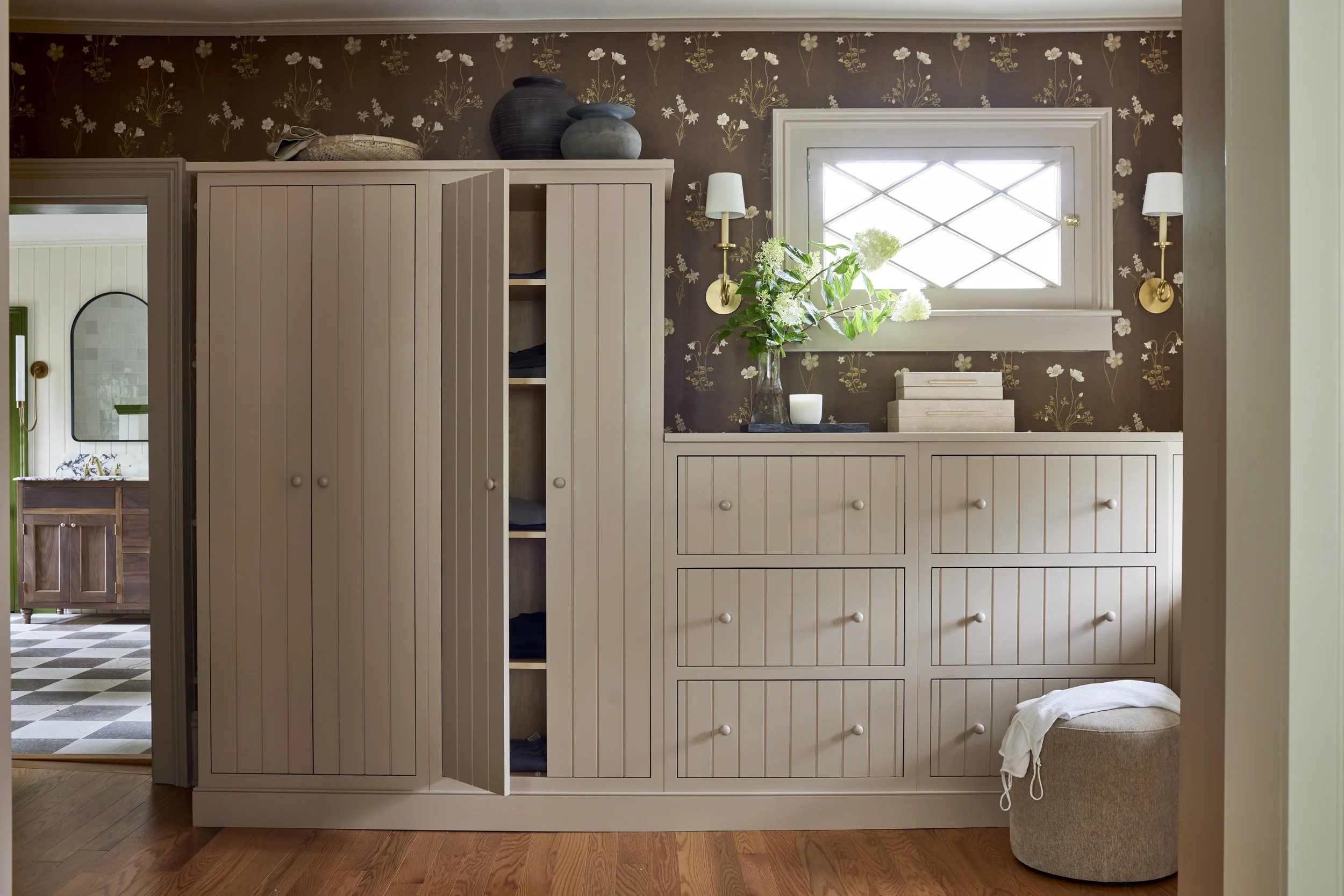 dressing room cabinetry with a shot of a bathroom in the background