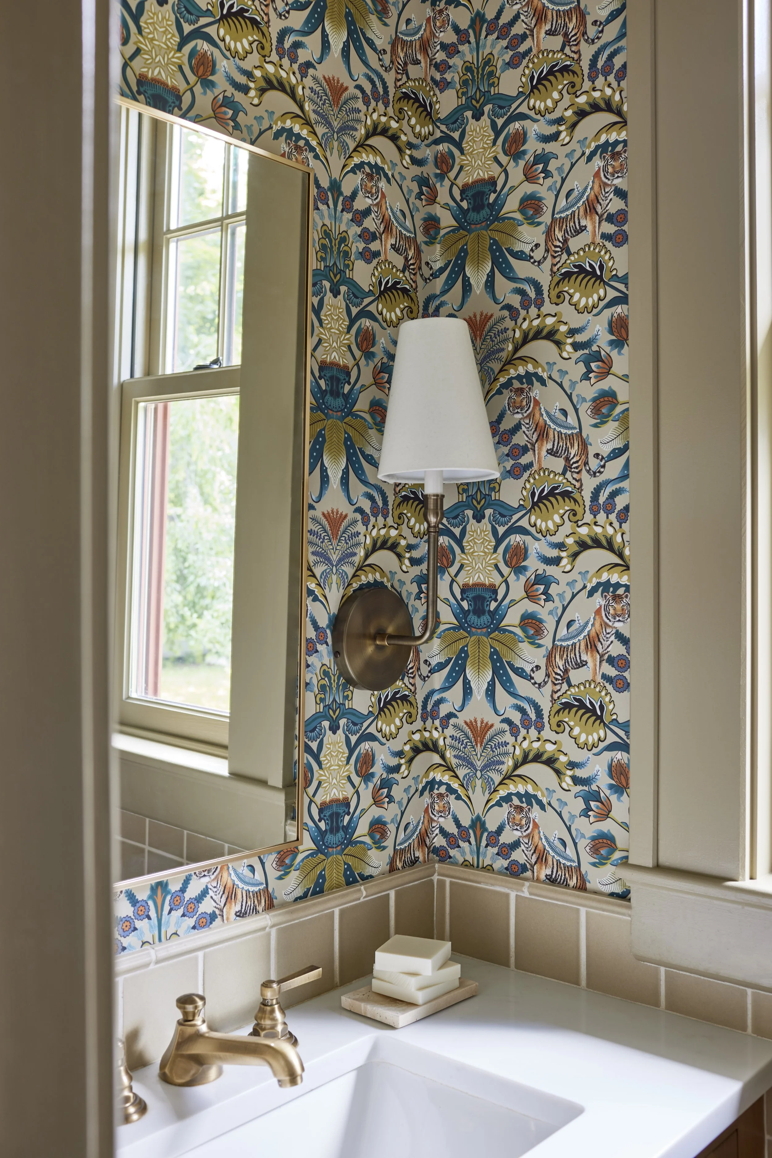 shot of corner with decorative wallpaper and wall sconce with white lampshade