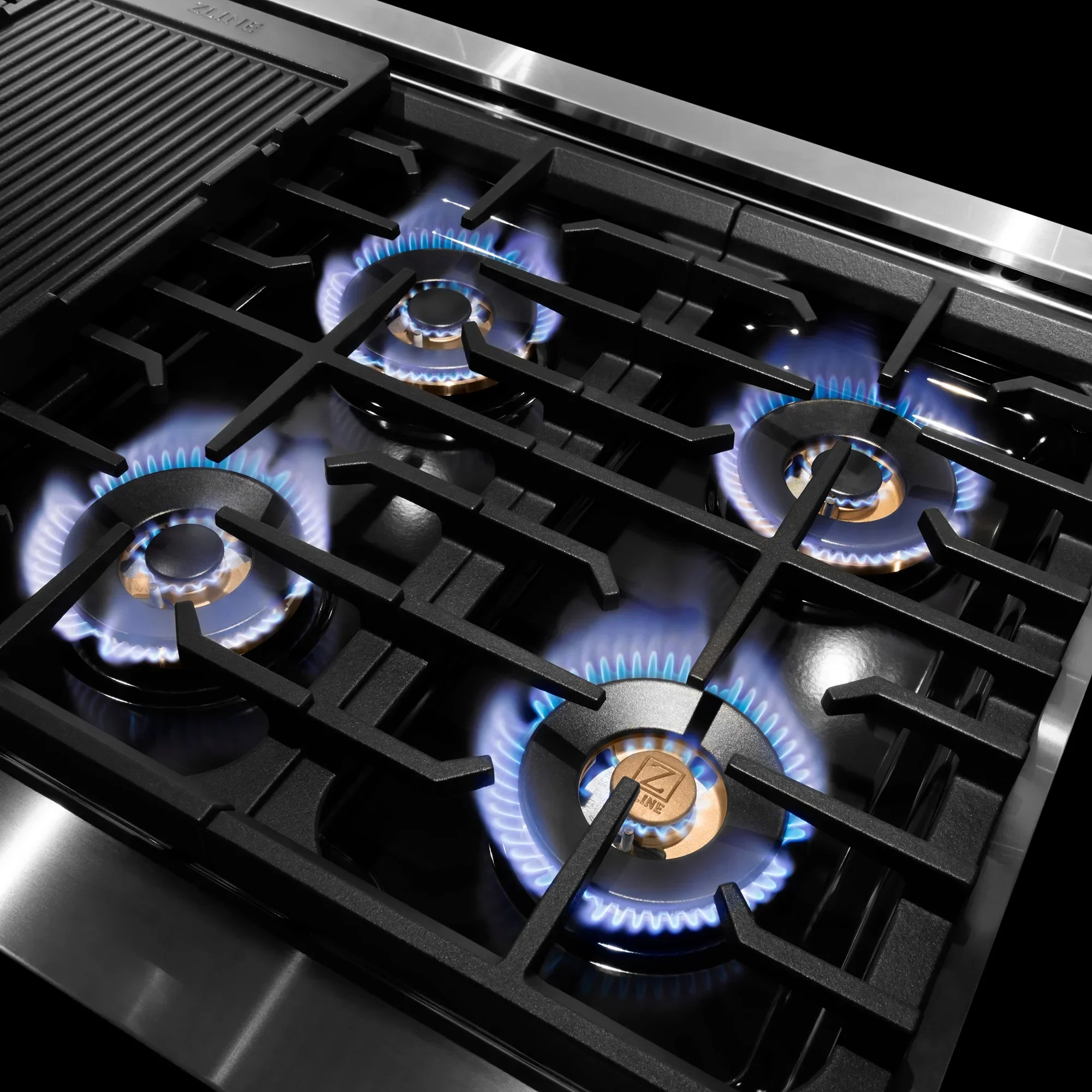 Stainless steel gas cooktop with burners and blue flames