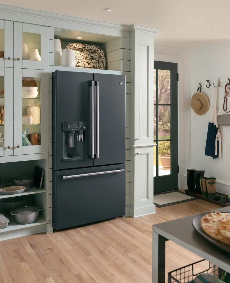Modern black refrigerator with glass door and water dispenser in a contemporary kitchen