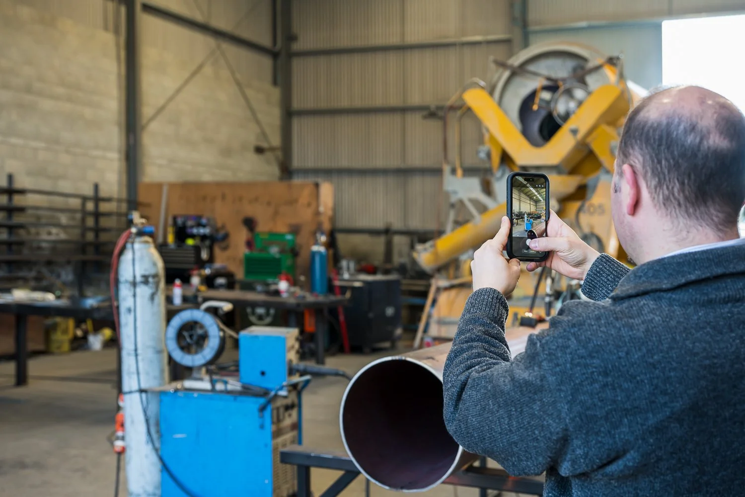One of the Bayleys Commercial Property Managers in a workshop property taking photos for an inspection.