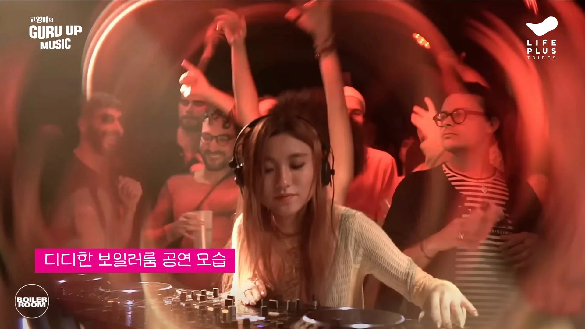 A woman DJ with headphones mixing music at a party, surrounded by people dancing and enjoying the music, with red lighting and a lively atmosphere.