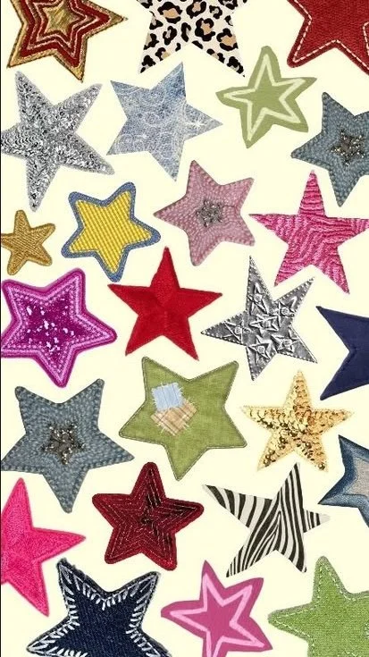 A collection of colorful star-shaped patches, each with different patterns and textures, scattered on a white background.