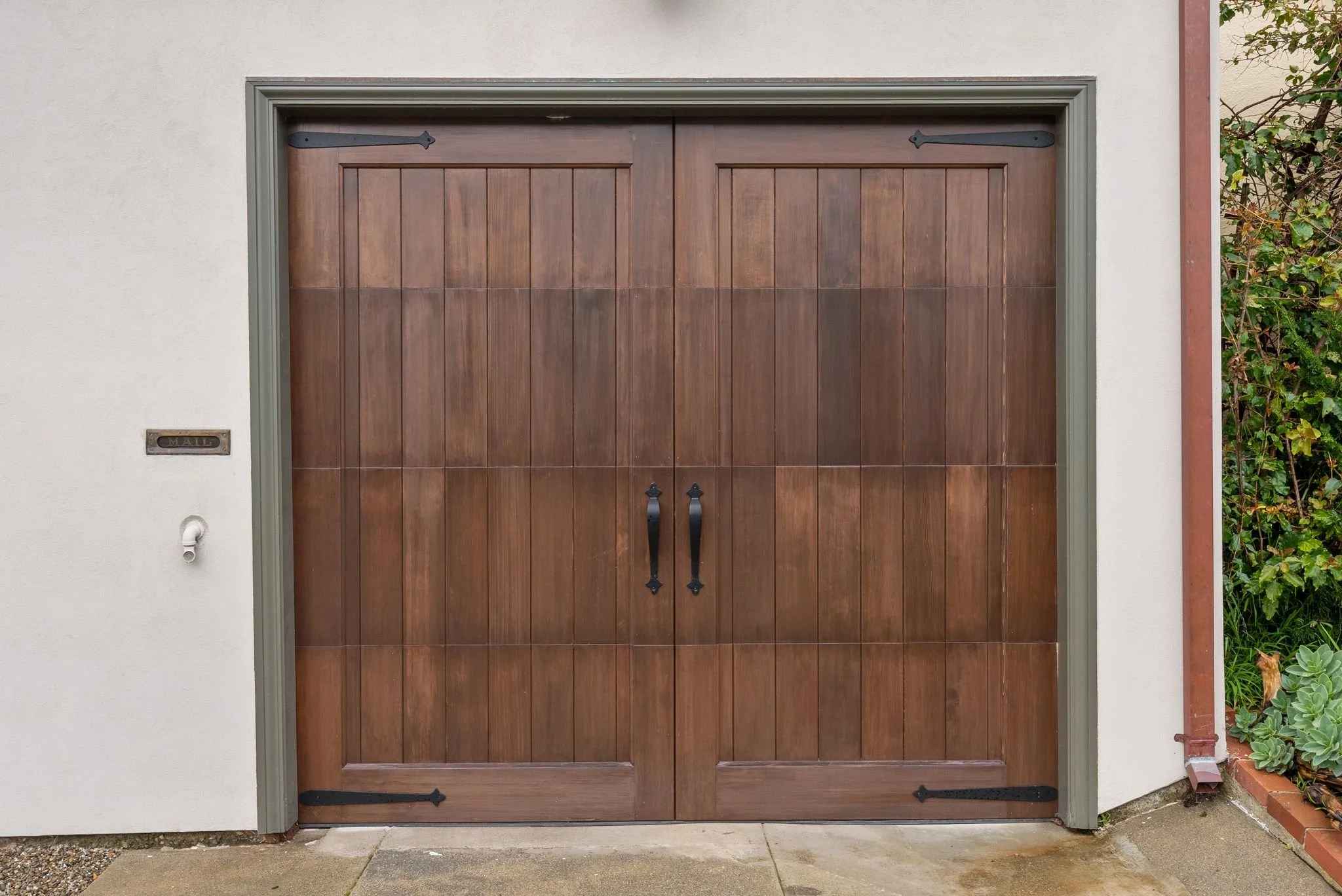 Custom wood double garage door set into a stucco facade