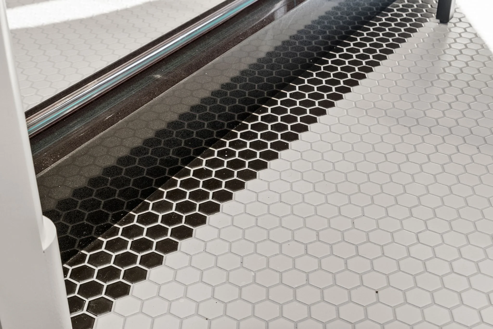 Black and white hexagon mosaic tile floor with black border stripe