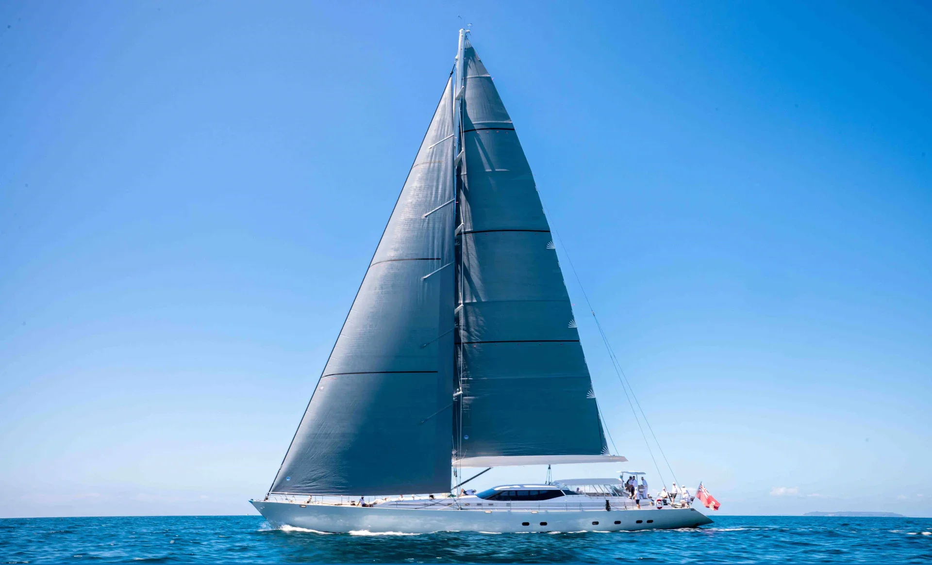 Radiance sailing with dark grey sails on blue water