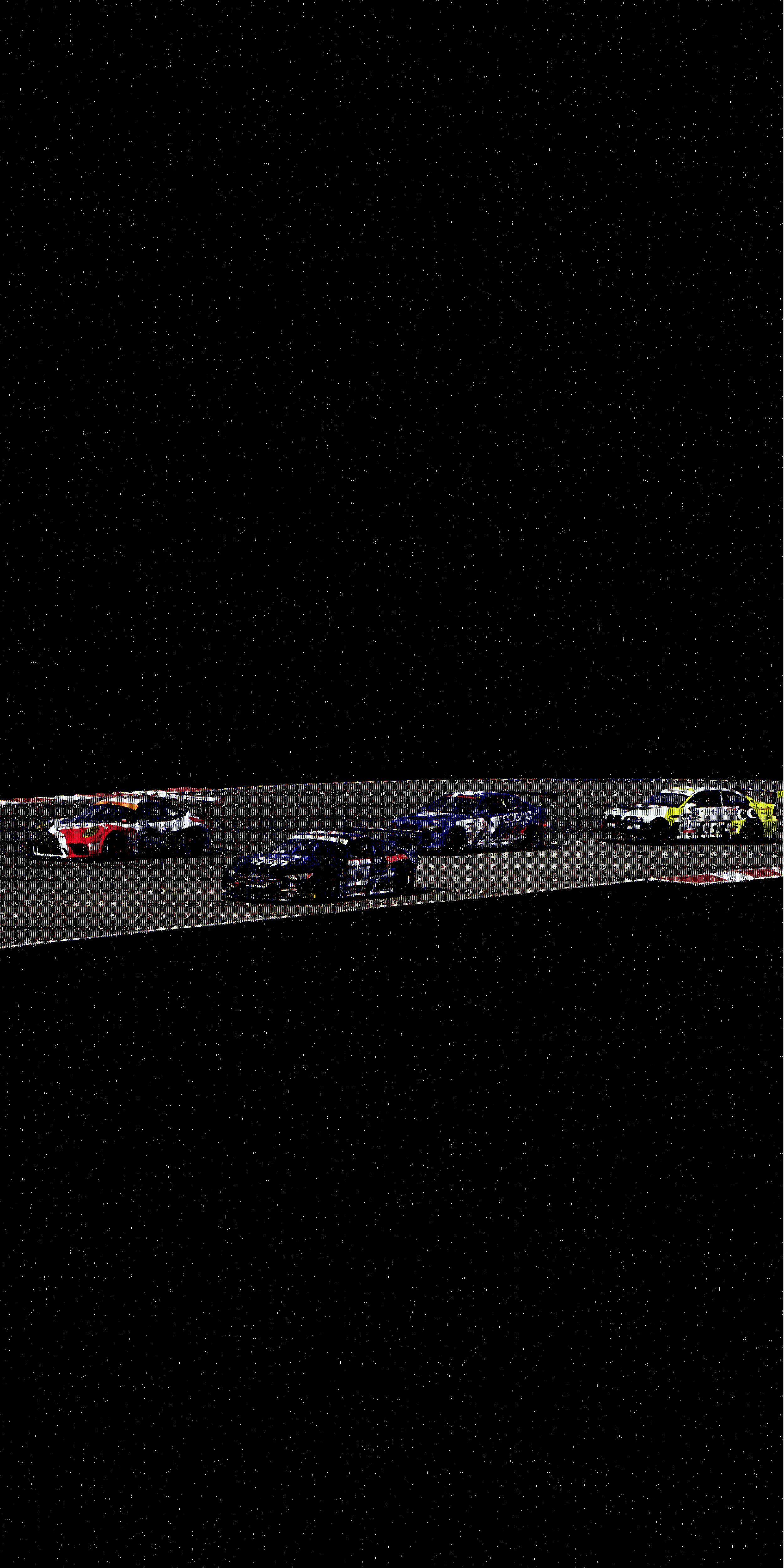 A group of race cars on a dark track at night, speeding around a corner with a starry sky in the background.