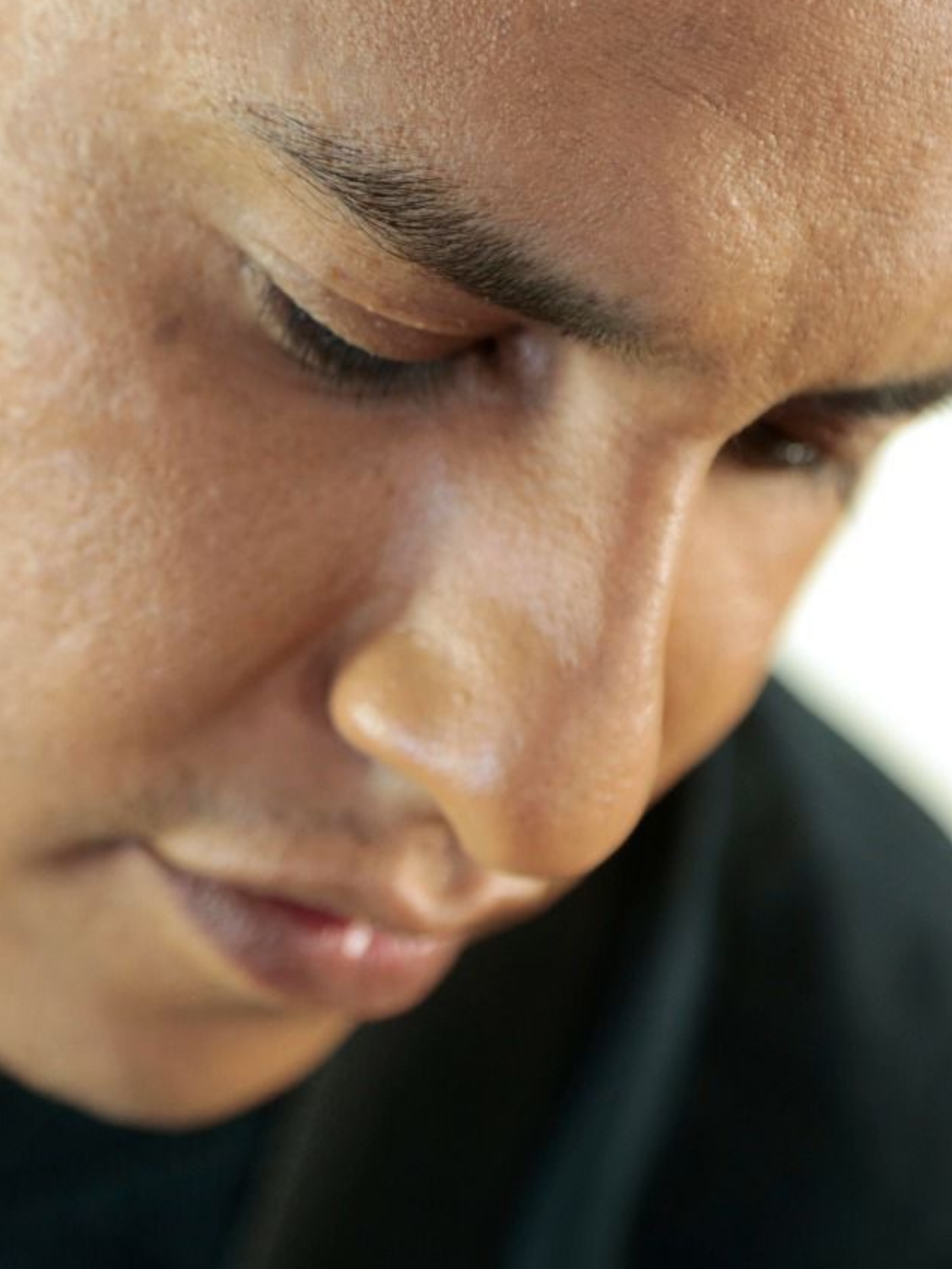 Close-up of a person's face, showing their closed eyes, eyebrows, and nose.