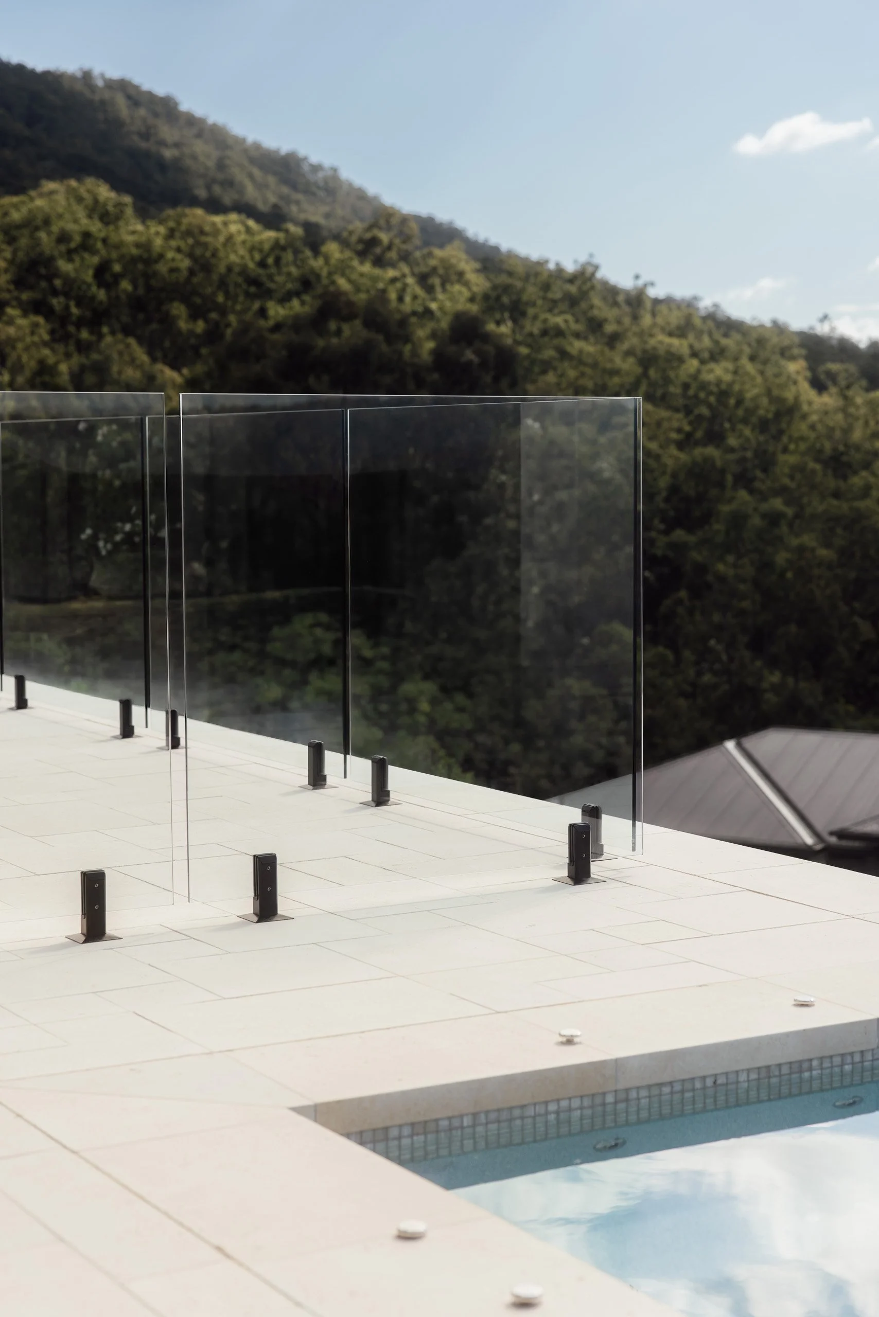 Architectural photography highlighting frameless glass pool fencing and uninterrupted views at the Canungra property.