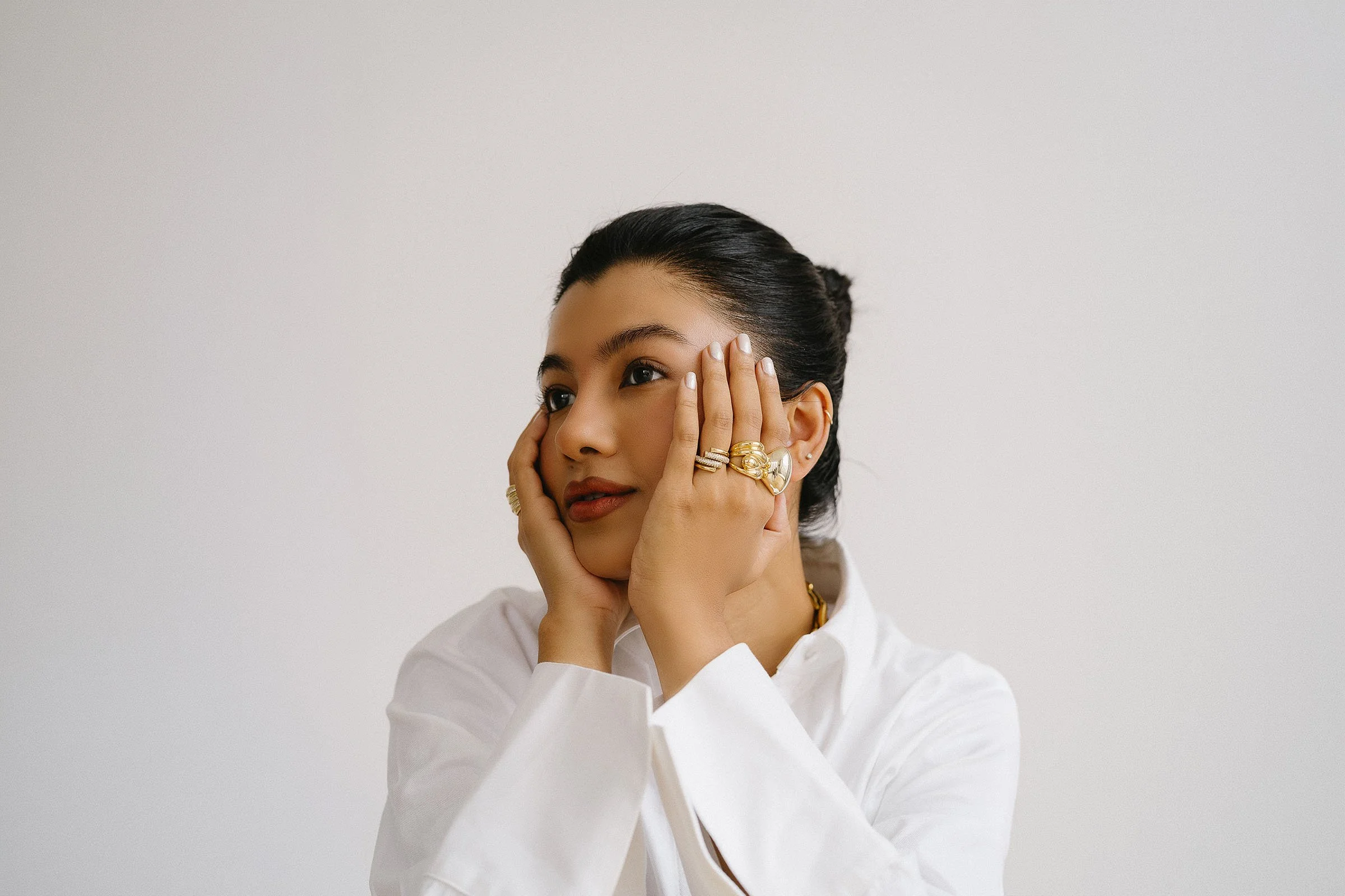 Campaign portrait created for Defoe & Co, featuring sculptural gold jewellery against clean white styling.