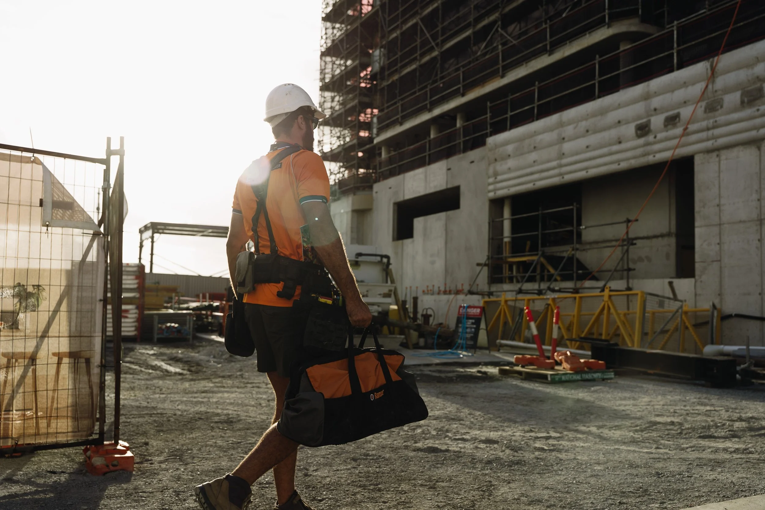 Construction worker carrying Ramset equipment onto a building site during the Next Generation Epoxy campaign.