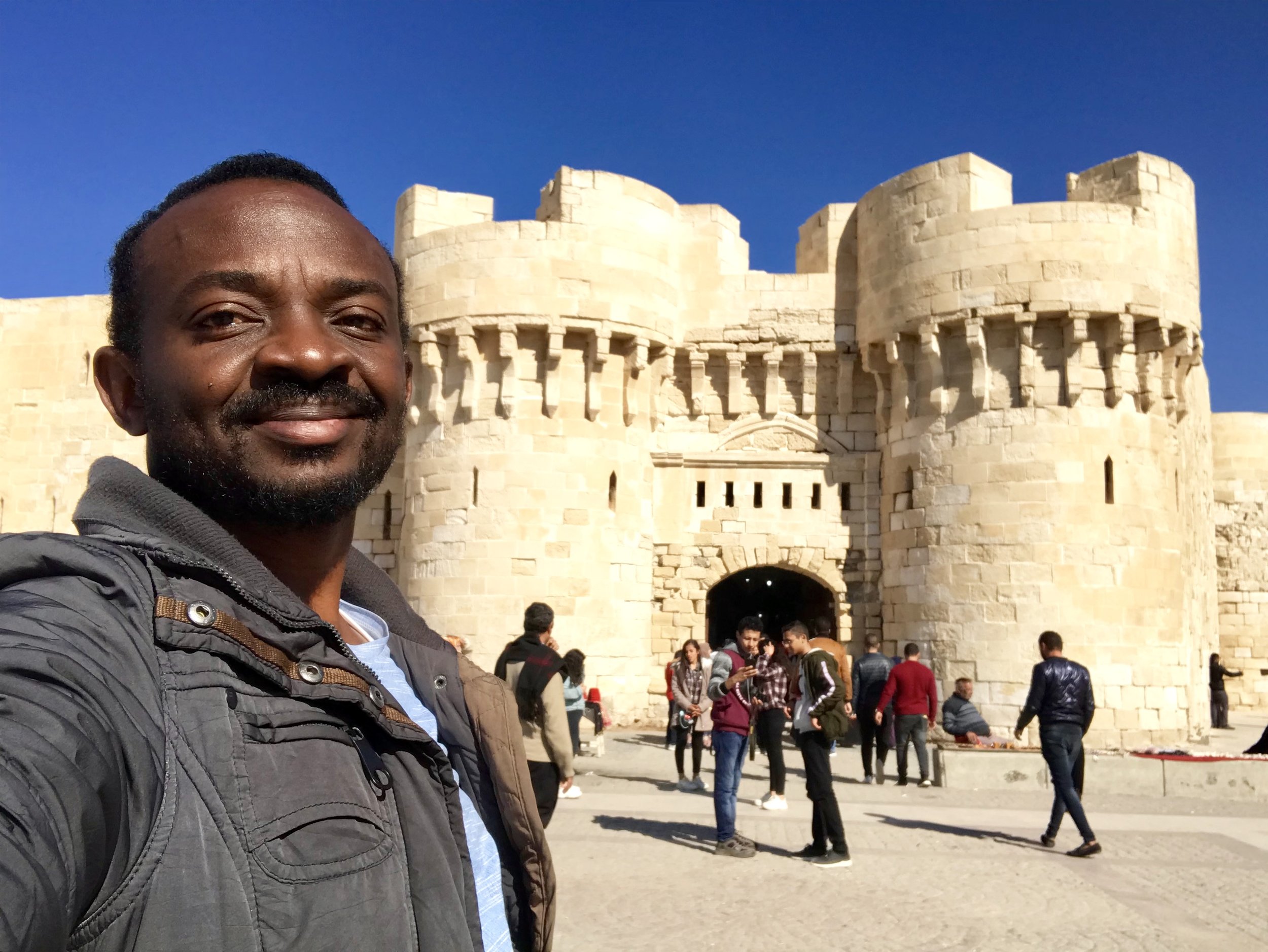 Jim Joel standing in front of the historic walls of Qaitbay Citadel in Alexandria, Egypt.