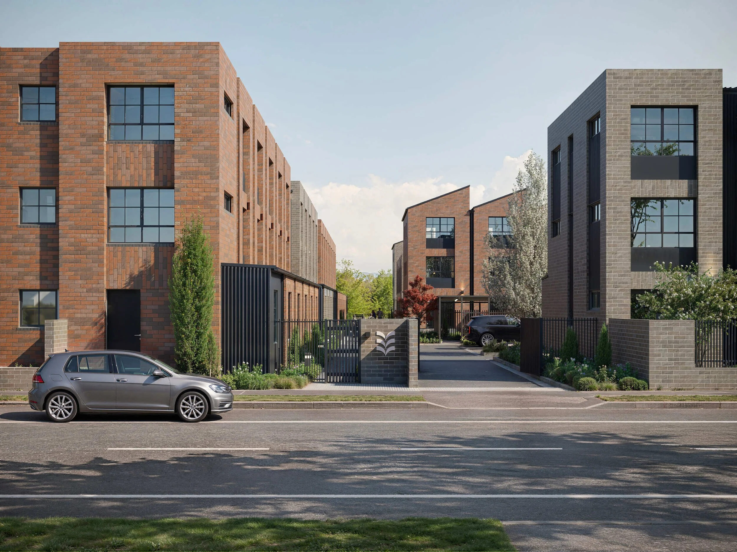 Modern residential buildings with brick and gray stone facades. A car is parked on the street in front, and there is greenery with trees and bushes around.