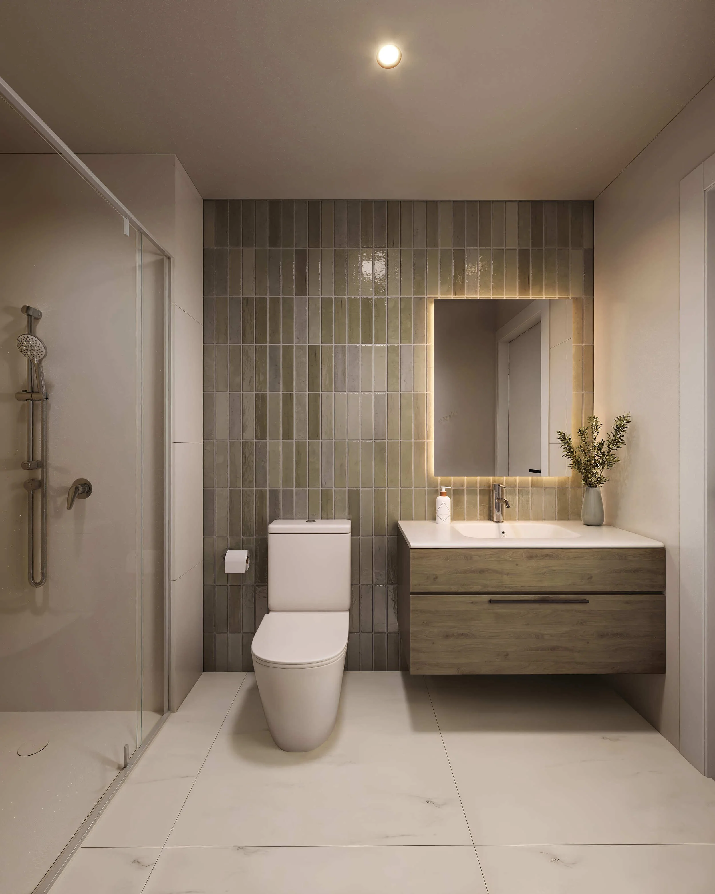 A modern bathroom with a wall-mounted mirror illuminated by LED lighting, a white toilet, a beige vanity with a white sink, a soap dispenser, and a decorative plant on the countertop. The wall behind the toilet and vanity is covered with beige tiles,