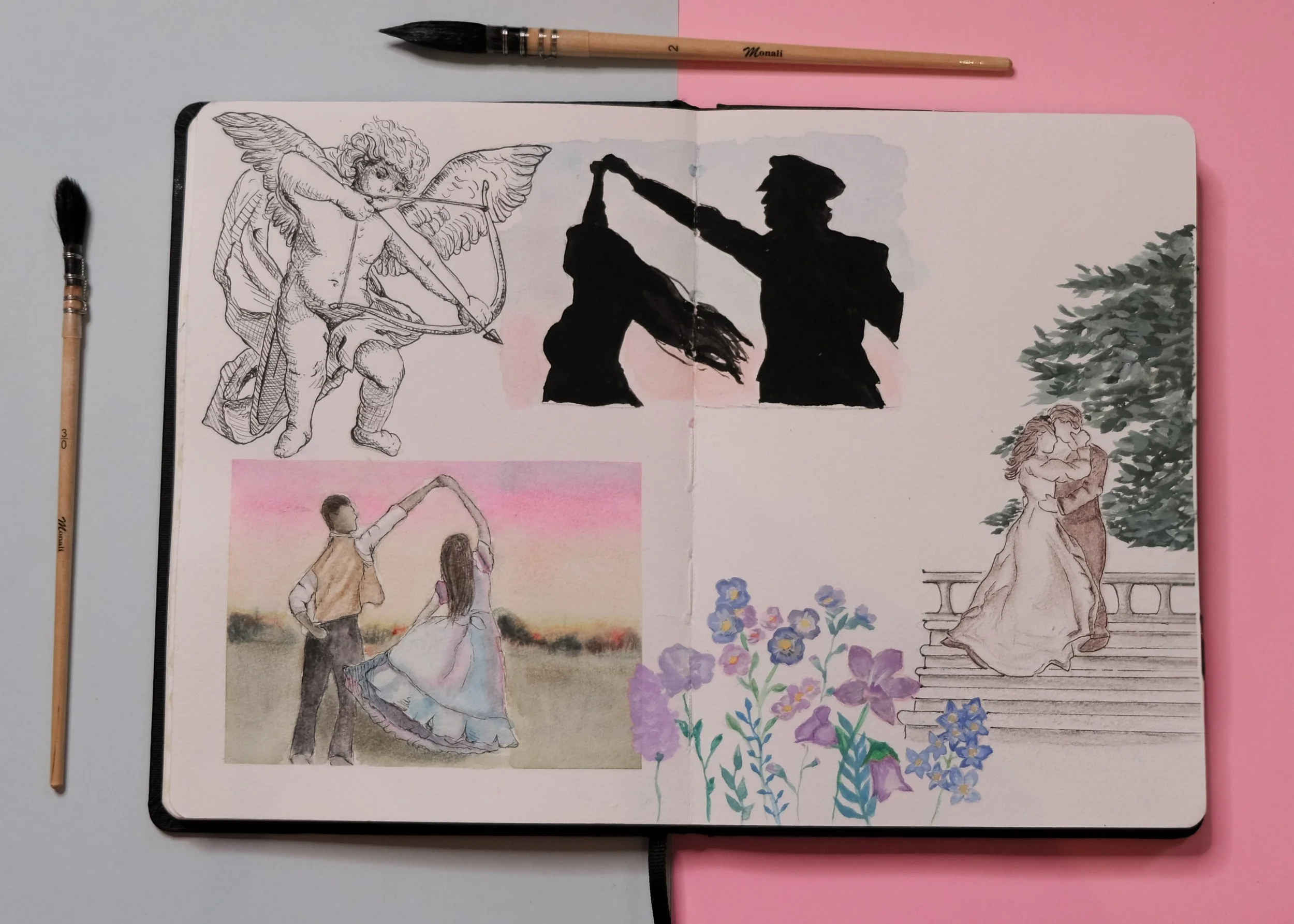 Un carnet de croquis ouvert avec des dessins, entouré de pinceaux, posé sur une surface bicolore, rose et gris, avec un décor de fleurs et de deux personnes dans une scène de danse.
