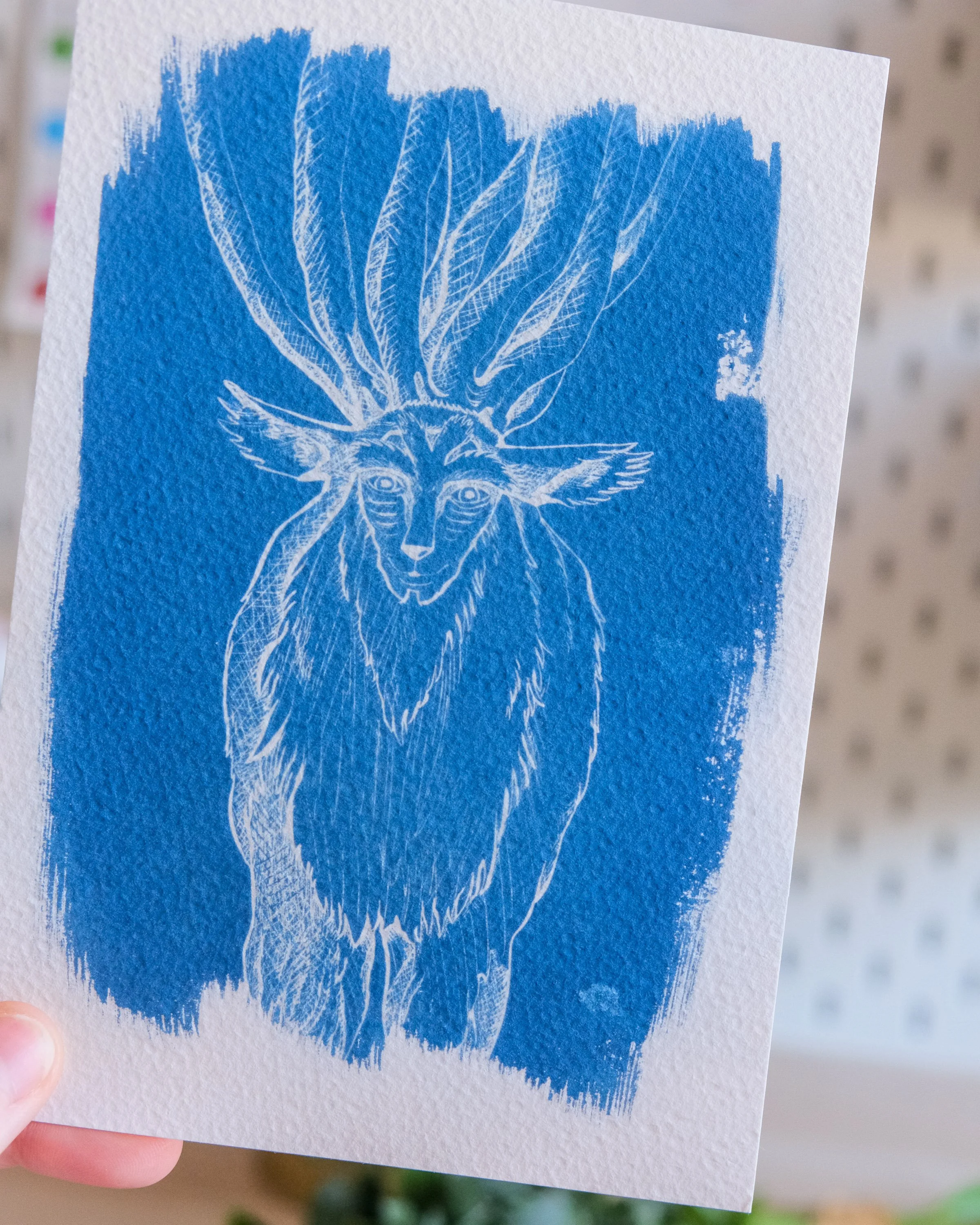 Une impression artistique en bleu et blanc représentant une tête de cerf stylisée, avec des branches ou des nervures s'étendant de la tête.